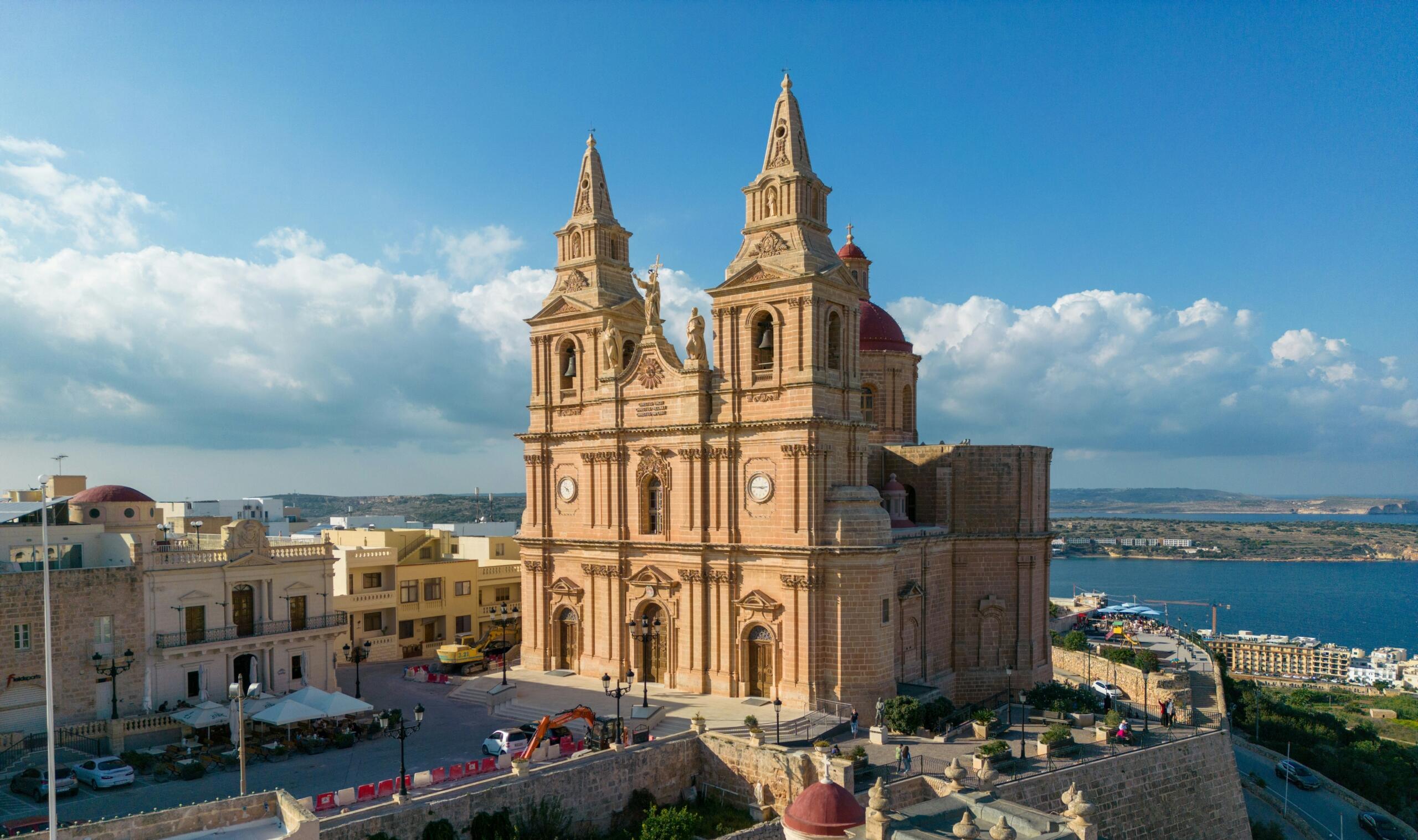 aerial view of a Maltese parish church at the heart of a village