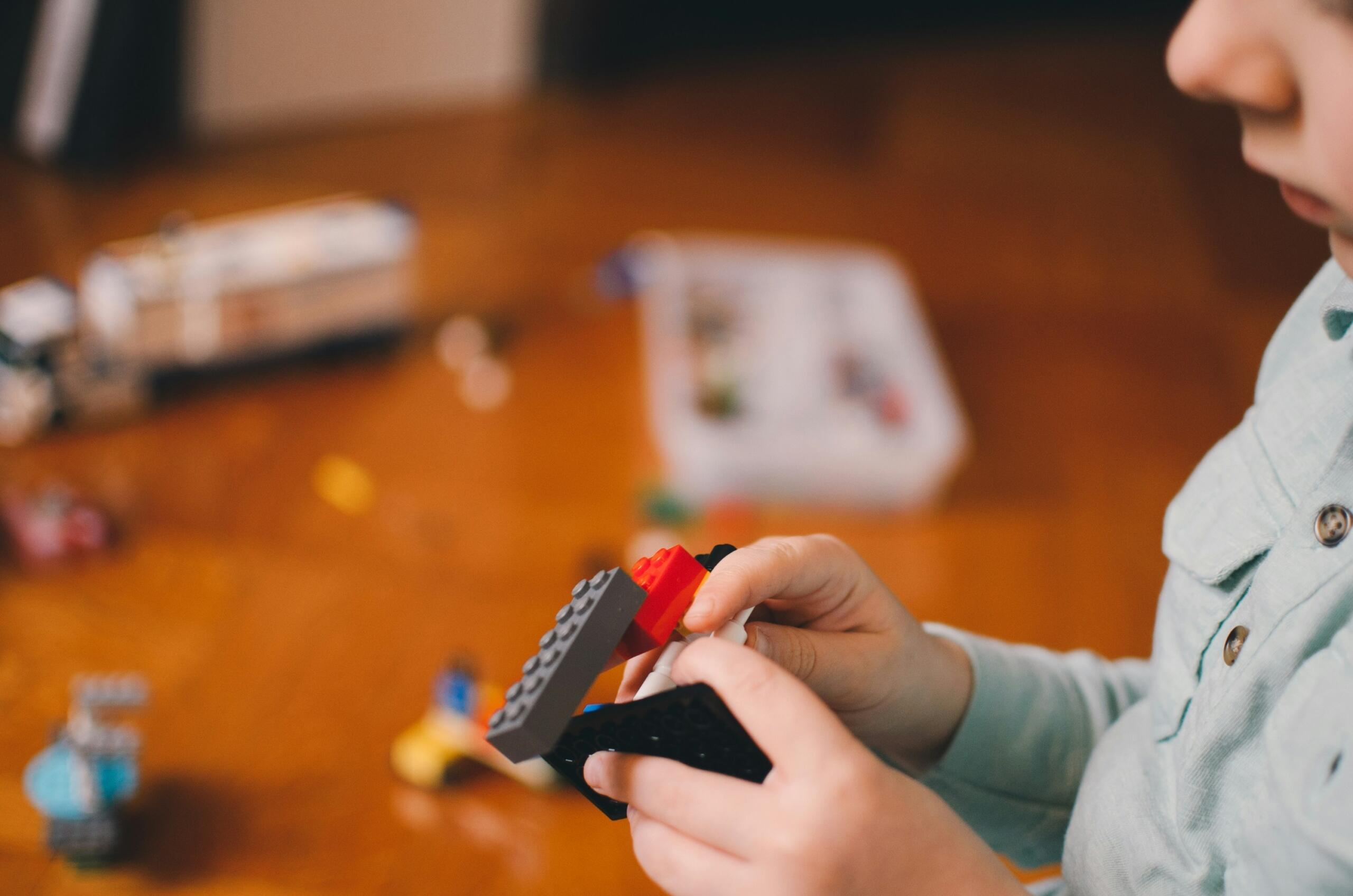 Child building a structure with colourful toy blocks