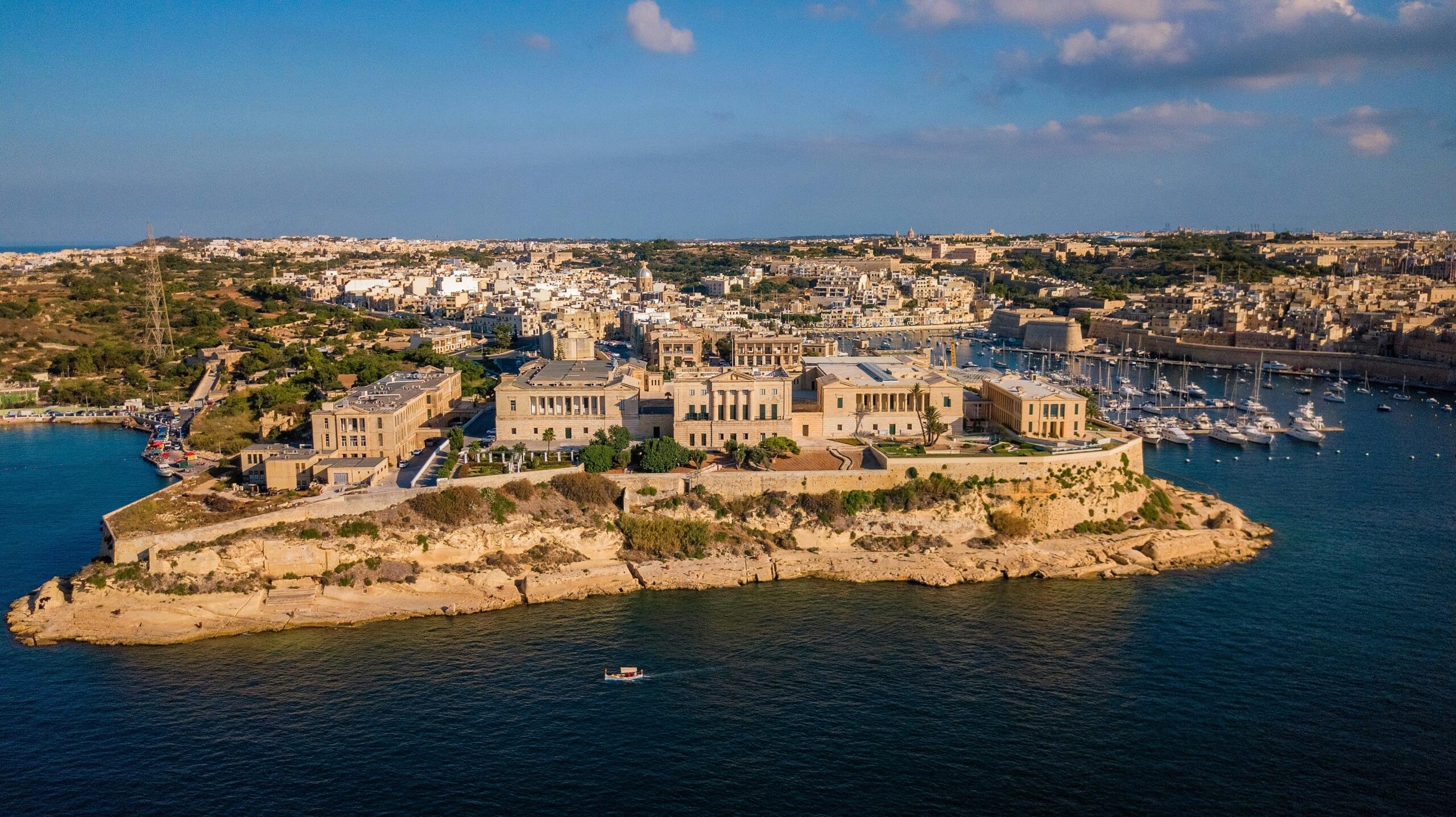 Aerial view of Malta coastline with historic buildings and harbour