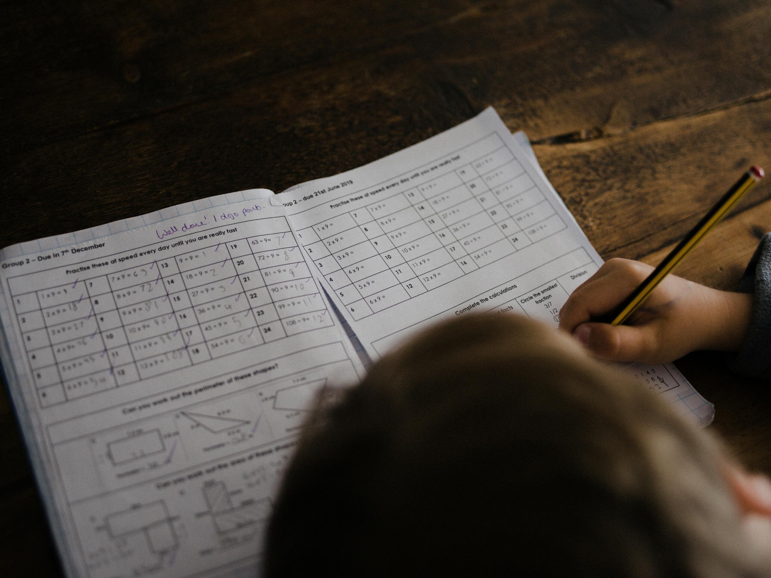 Boy writing in a notebook at a desk