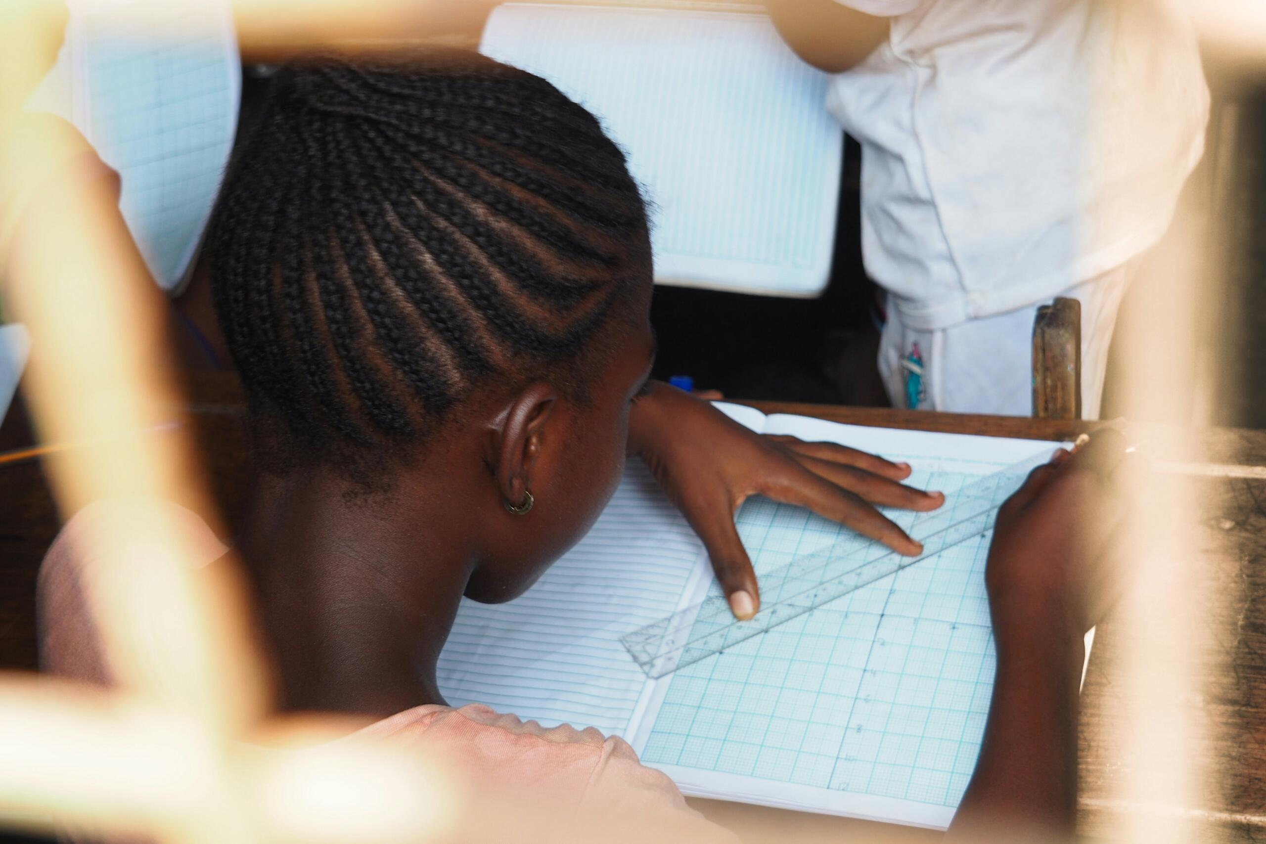 Student using a ruler to draw lines during a maths lesson