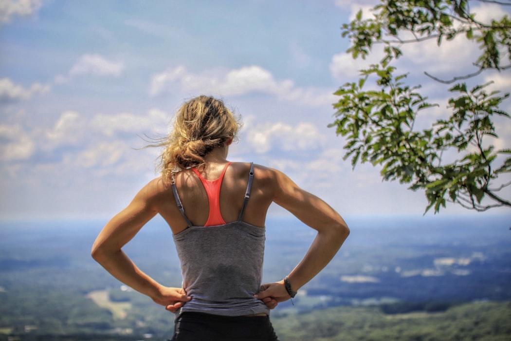 Deportista con peto mirando desde un cerro