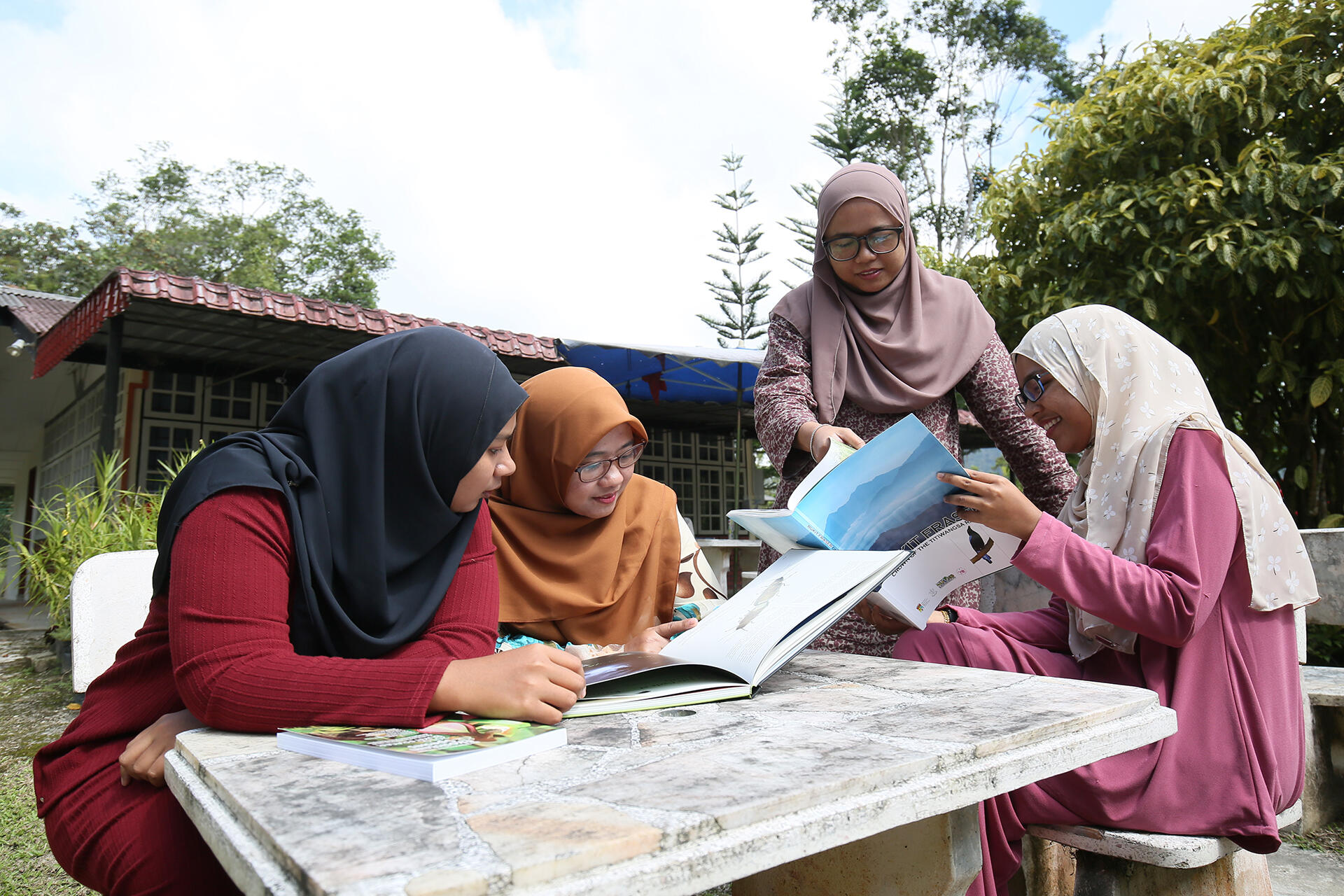 Group of female students having a discussion while flipping through books
