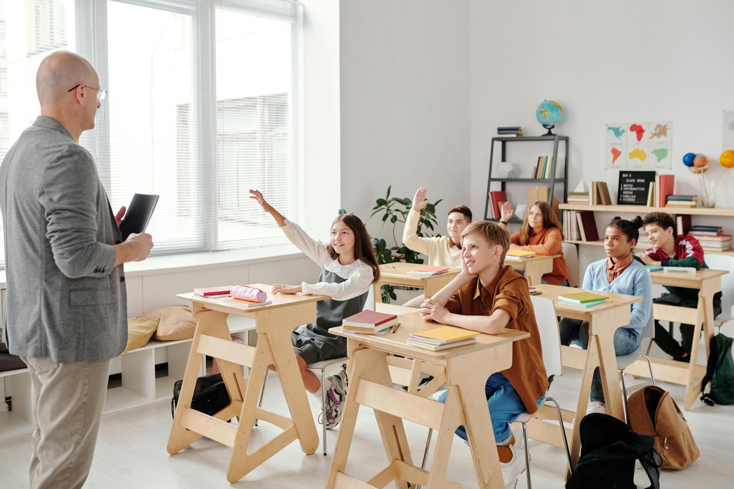 Students raising hands in a classroom