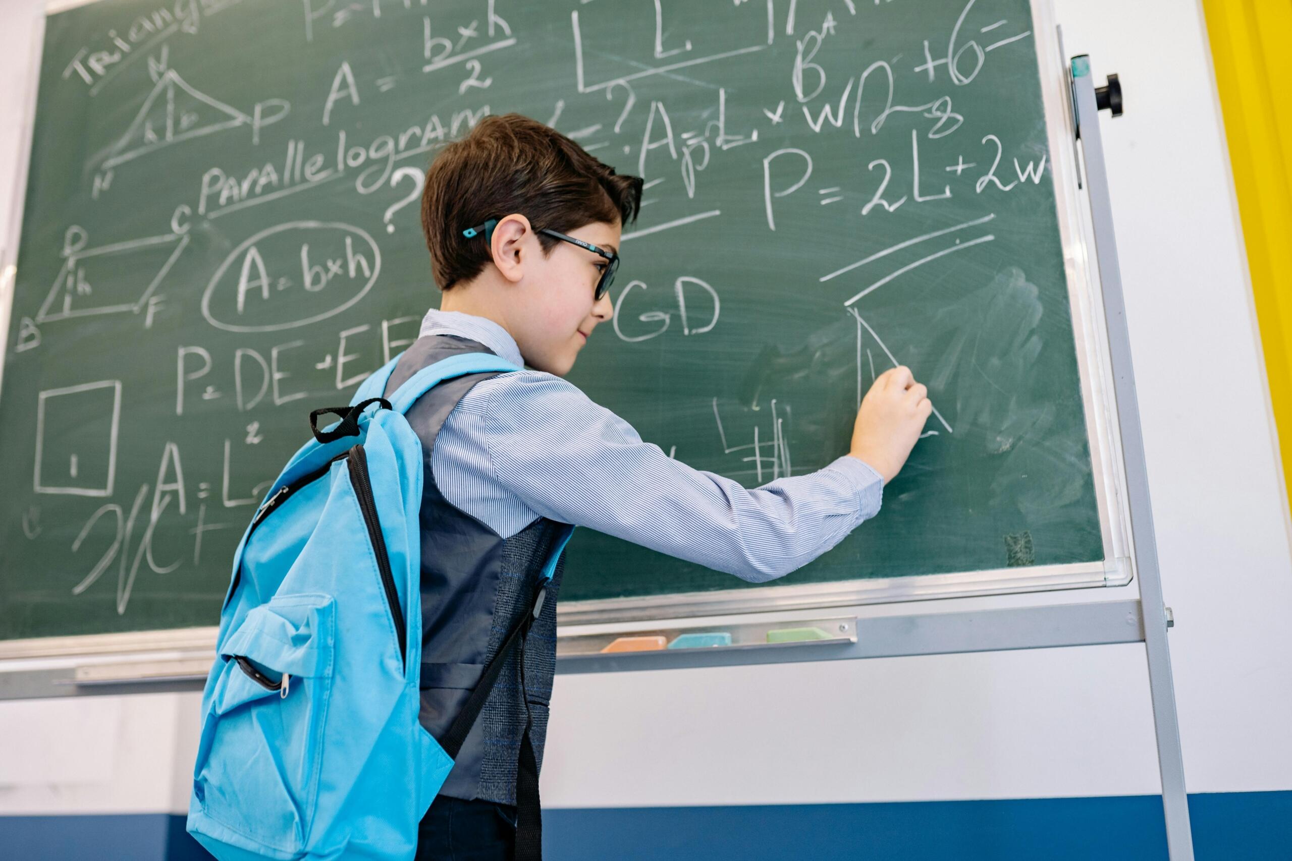 Boy solving a math problem on the blackboard