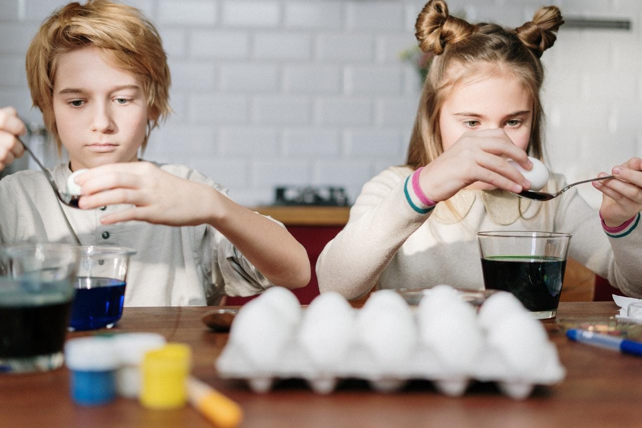 siblings painting eggs