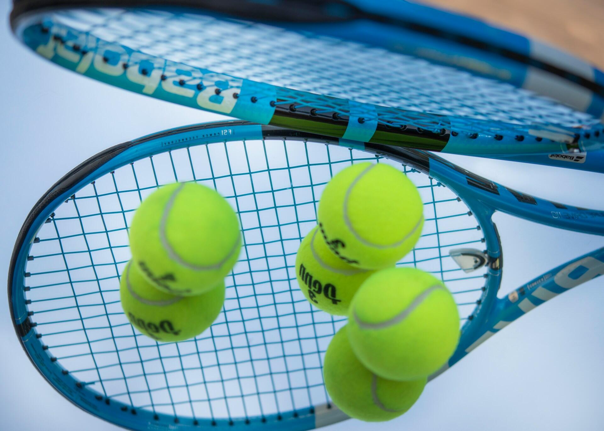 Blue racquet with yellow tennis balls.