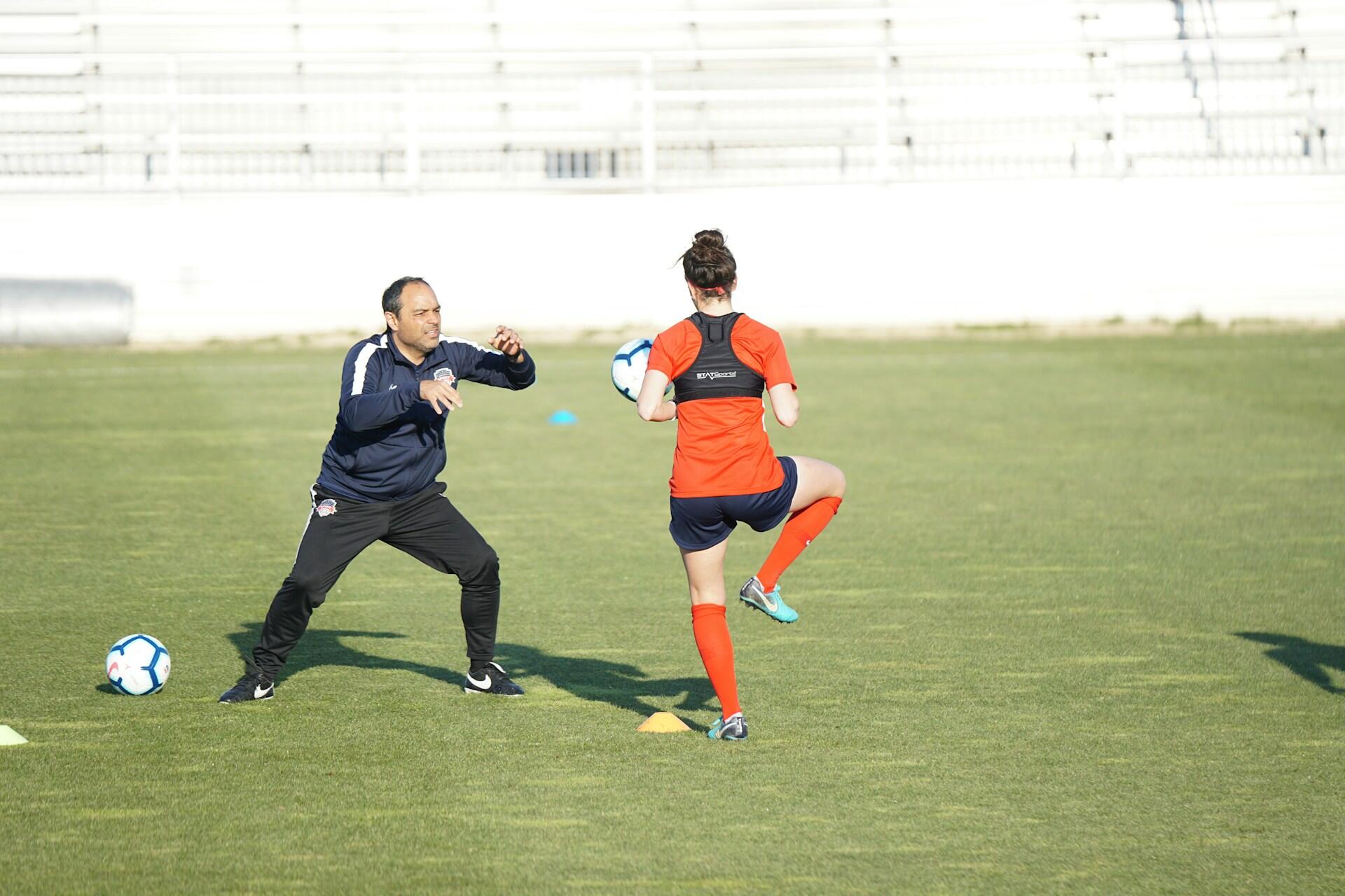 A coach and a player on the grass field.