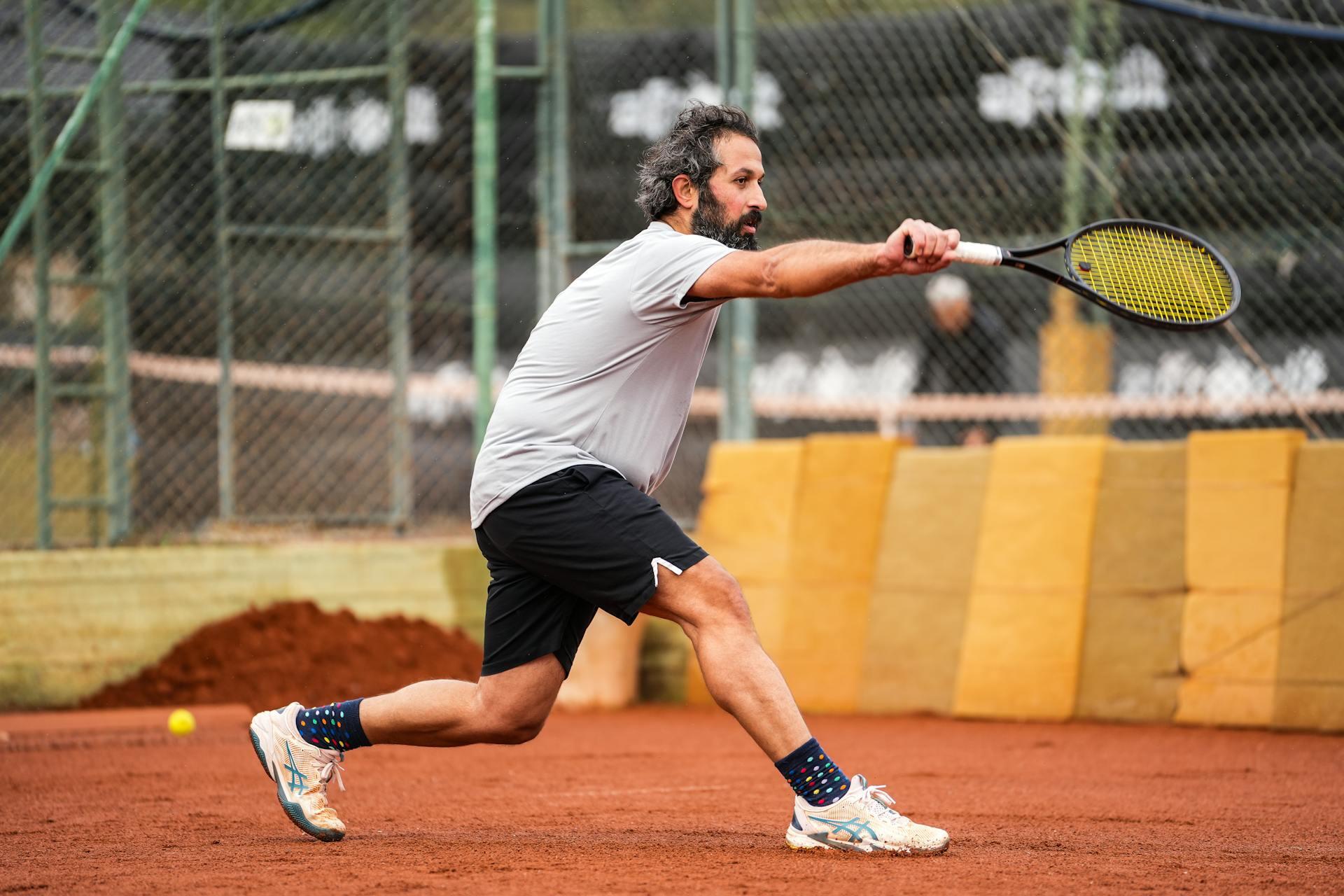 A tennis player in action on a clay court. 