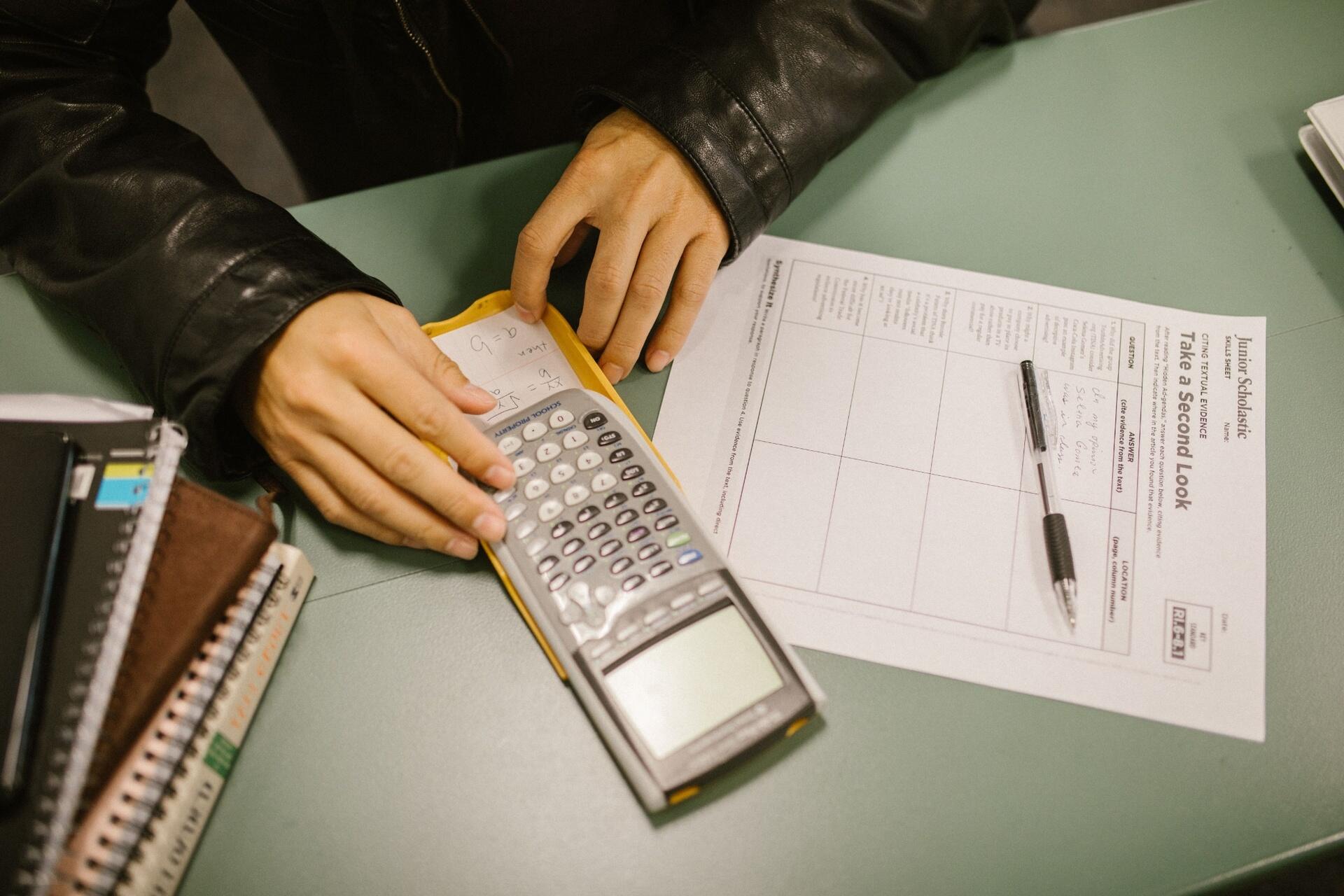 Student solving maths problem using calculator