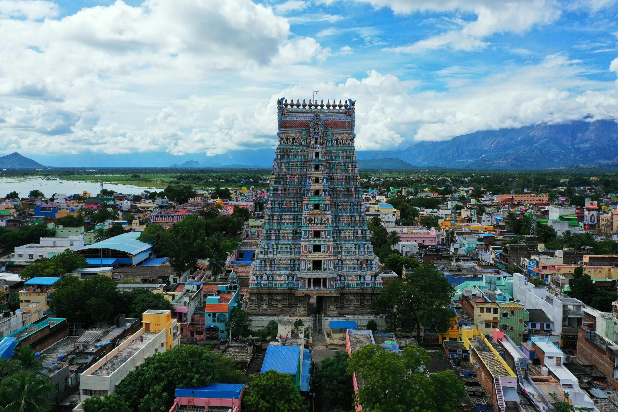Aerial view of a South Indian temple tower rising above an urban landscape, showcasing traditional Dravidian architecture and Tamil cultural heritage.