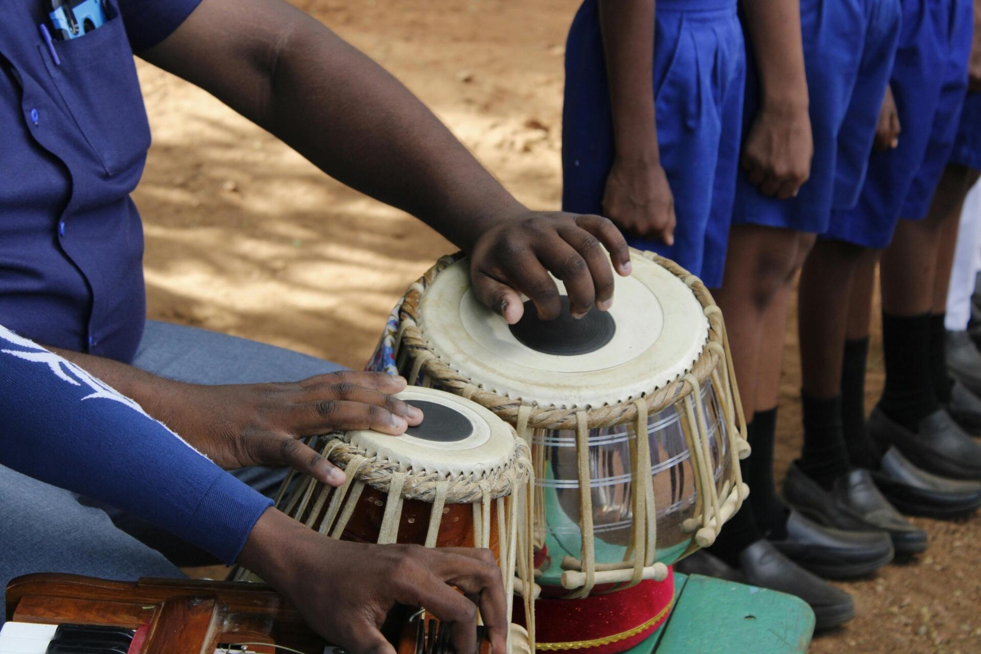 Students playing traditional Indian tabla drums during a cultural music activity