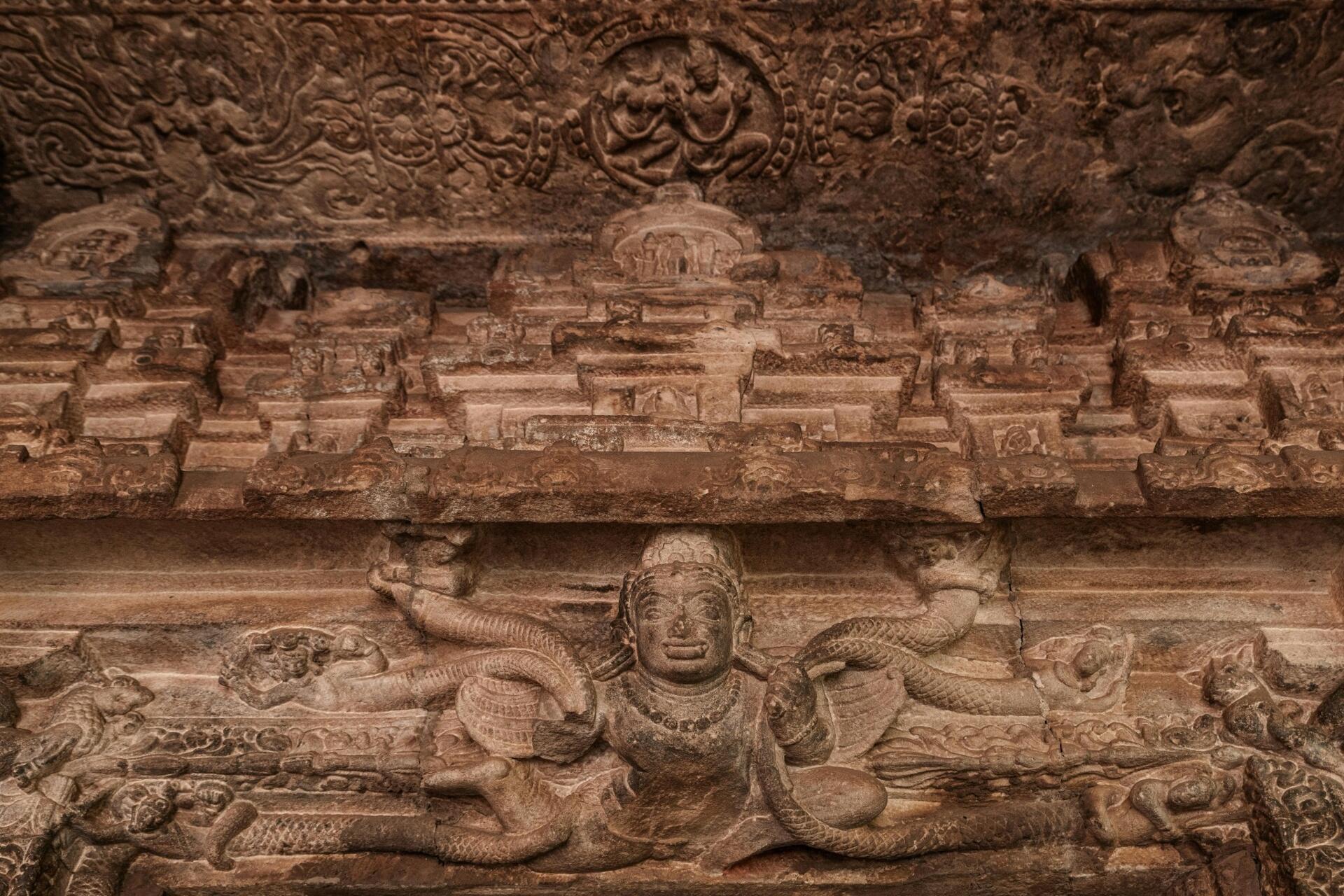 Ancient South Indian temple stone carving featuring detailed Tamil-era sculptures and mythological figures