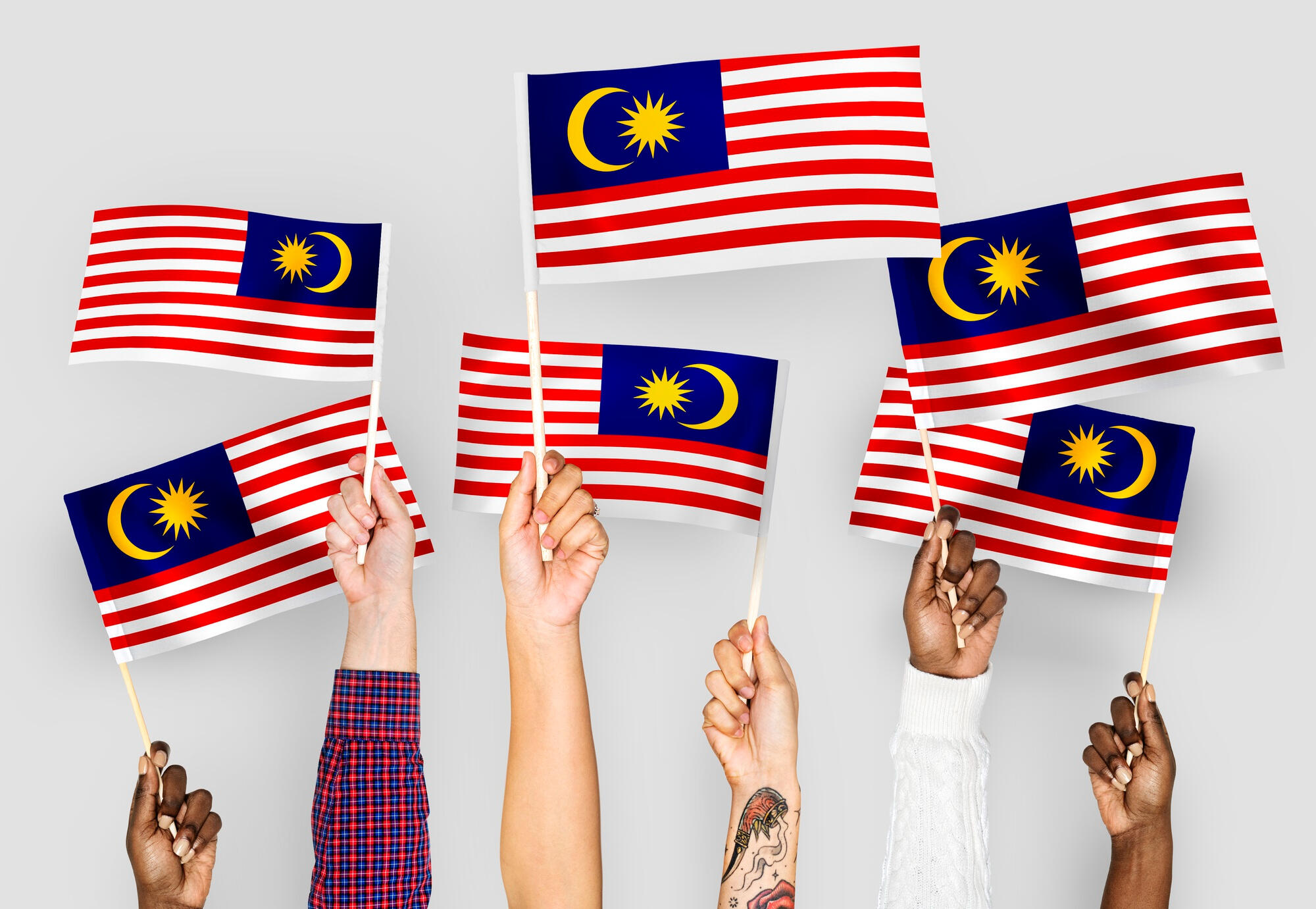 Hands waving flags of Malayisa