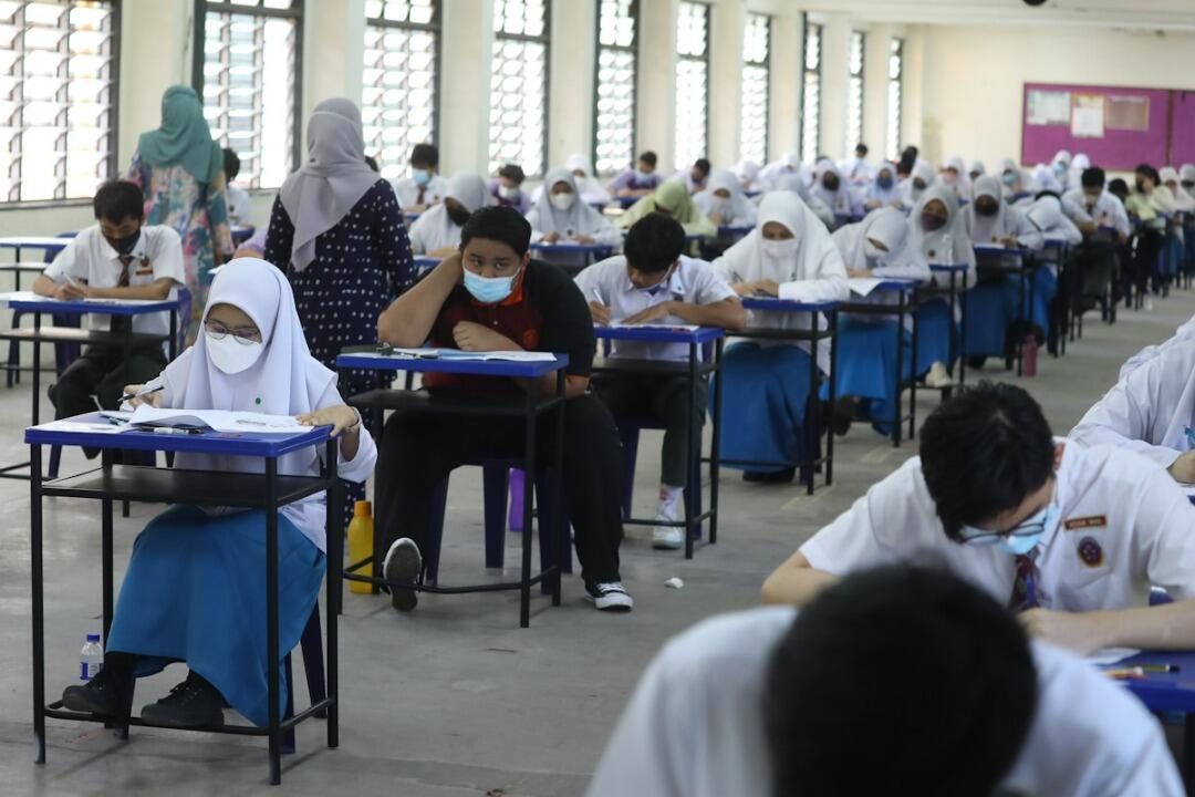 Students taking exam in an exam hall.