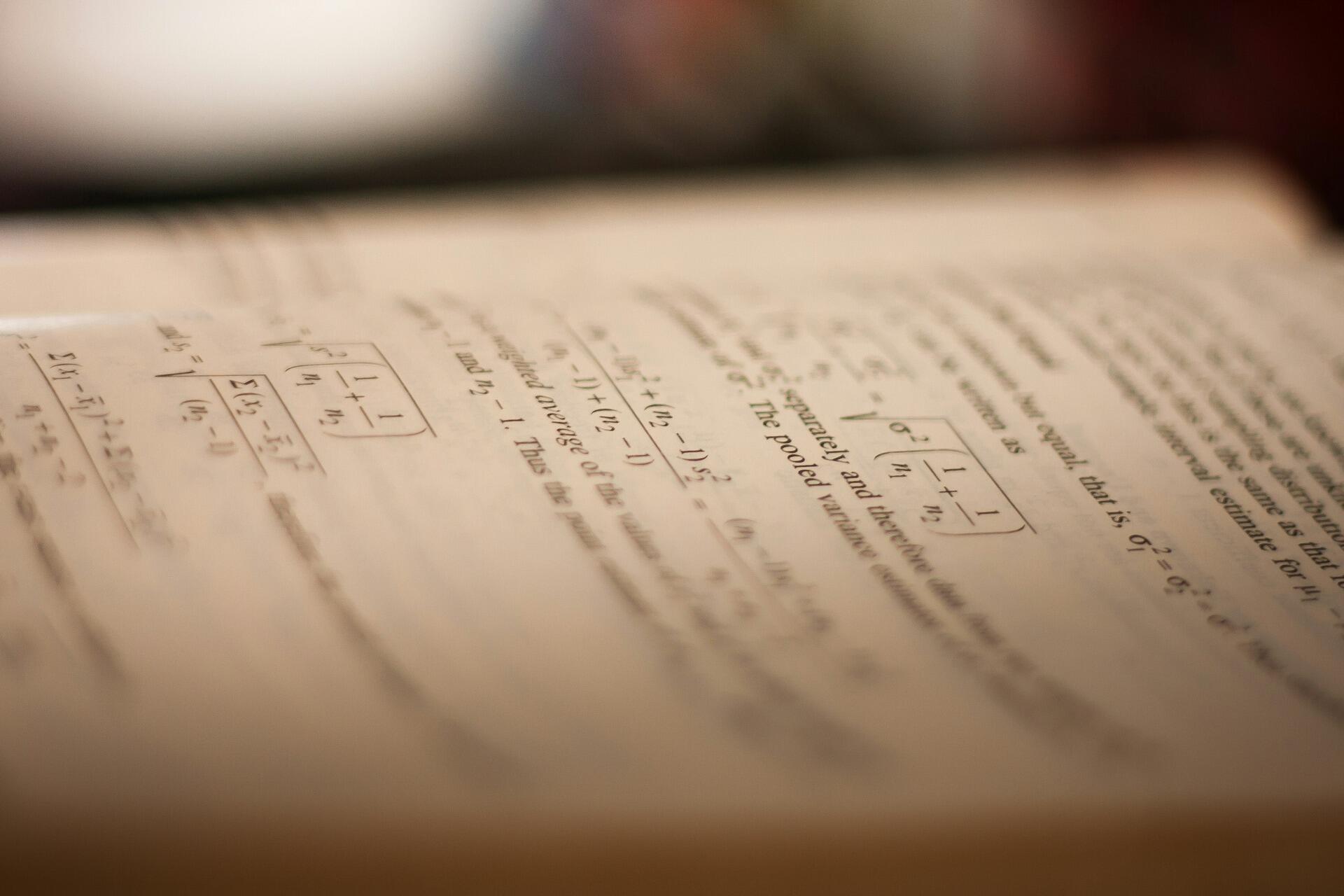 Open statistics textbook showing mathematical formulas and equations related to hypothesis testing and variance estimation.