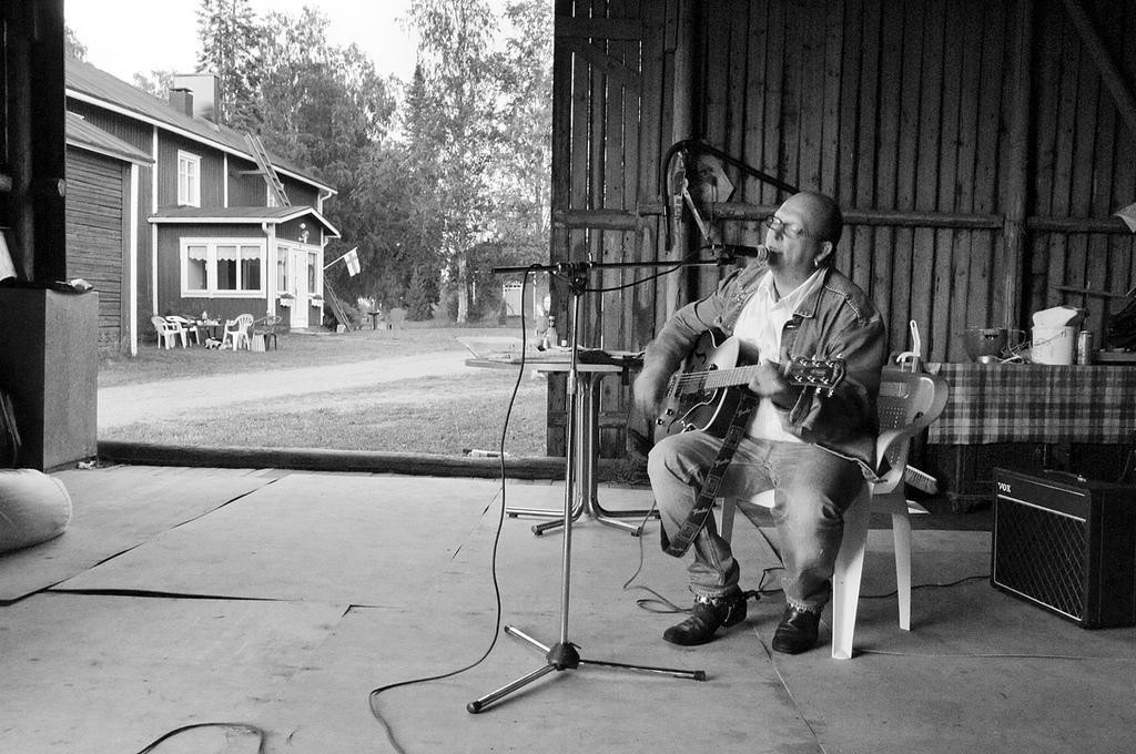 A guitarist plays in a shed.