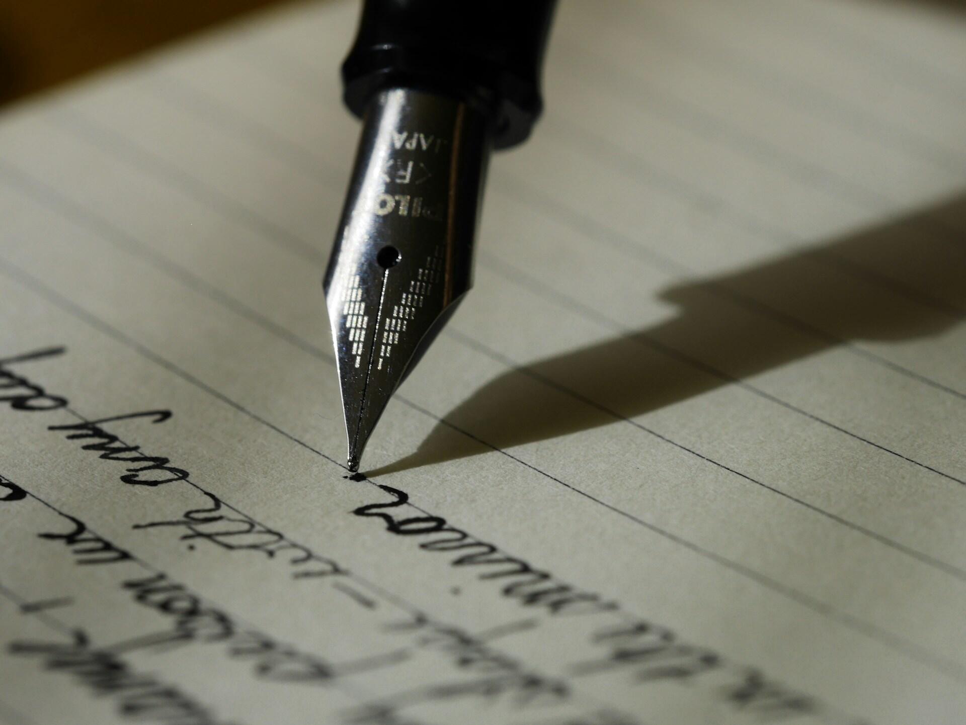 A fountain pen writes on paper