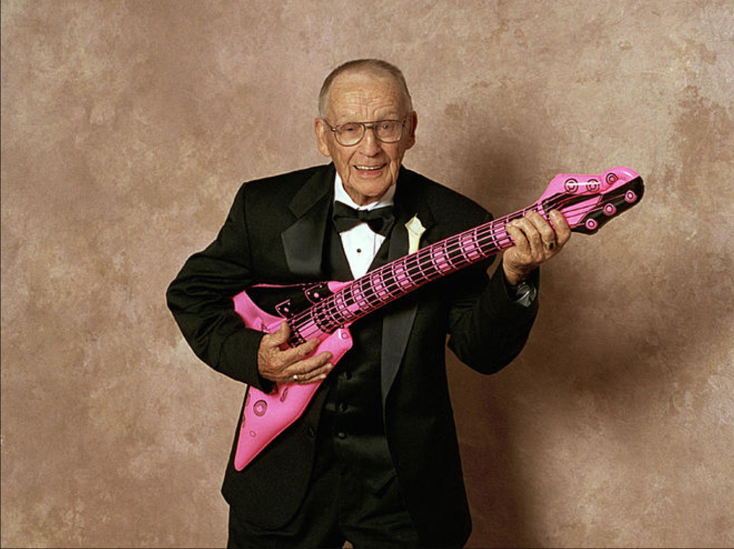 an elderly man plays the guitar