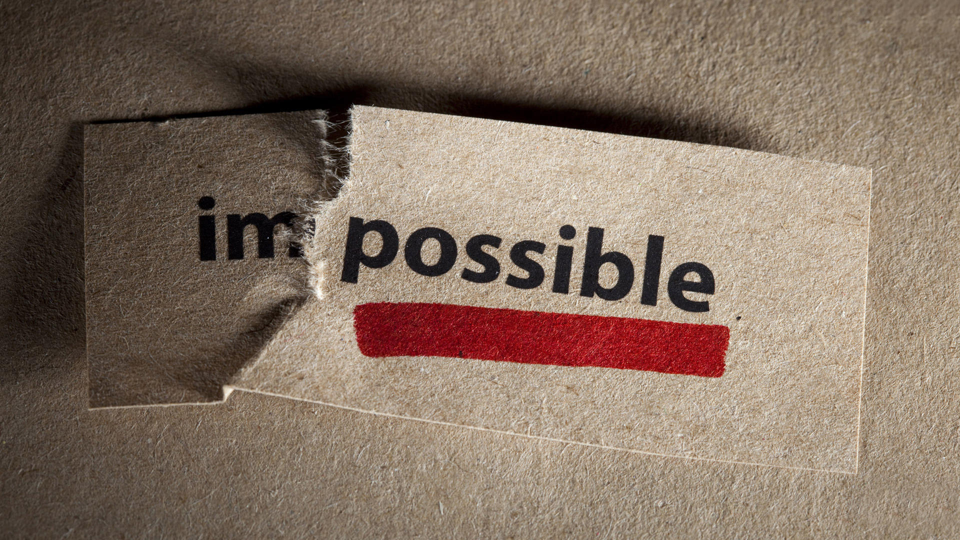 A card reading 'impossible' torn after the 'im-'