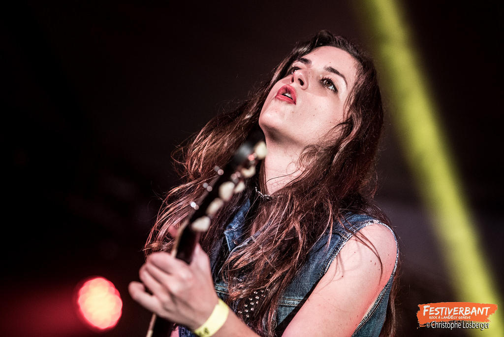 a woman playing guitar on stage