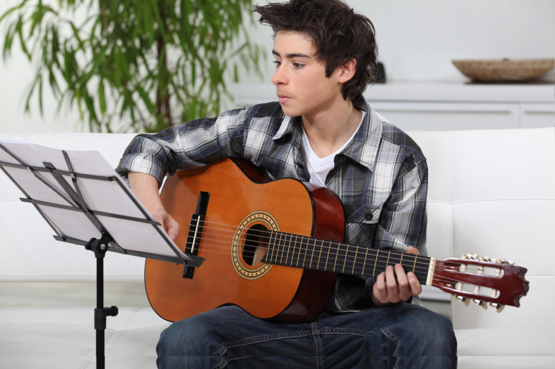 A young man learning the guitar
