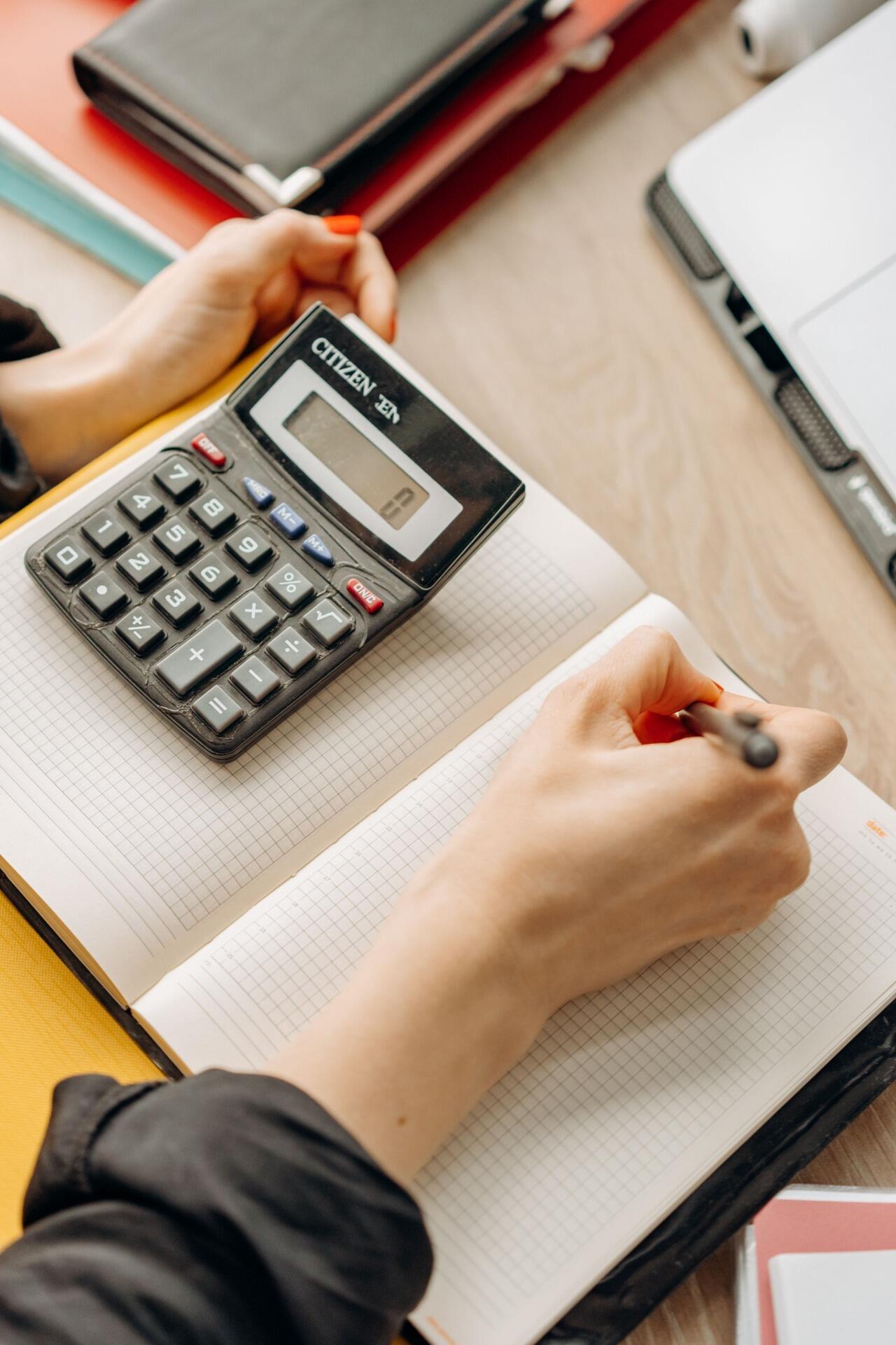 Student using a calculator and notebook while practising STPM Mathematics.