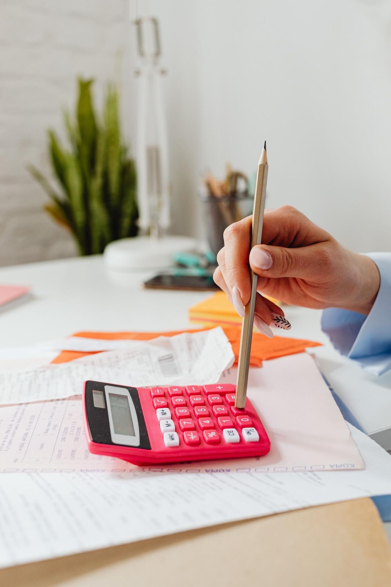 Student using a calculator and pencil while working through mathematics papers for STPM exam practice.