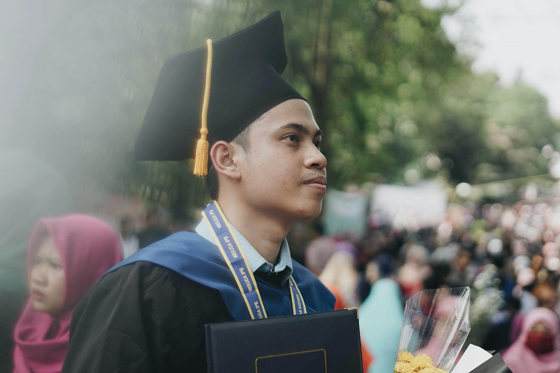 Man on a graduation attire posing for a photo.