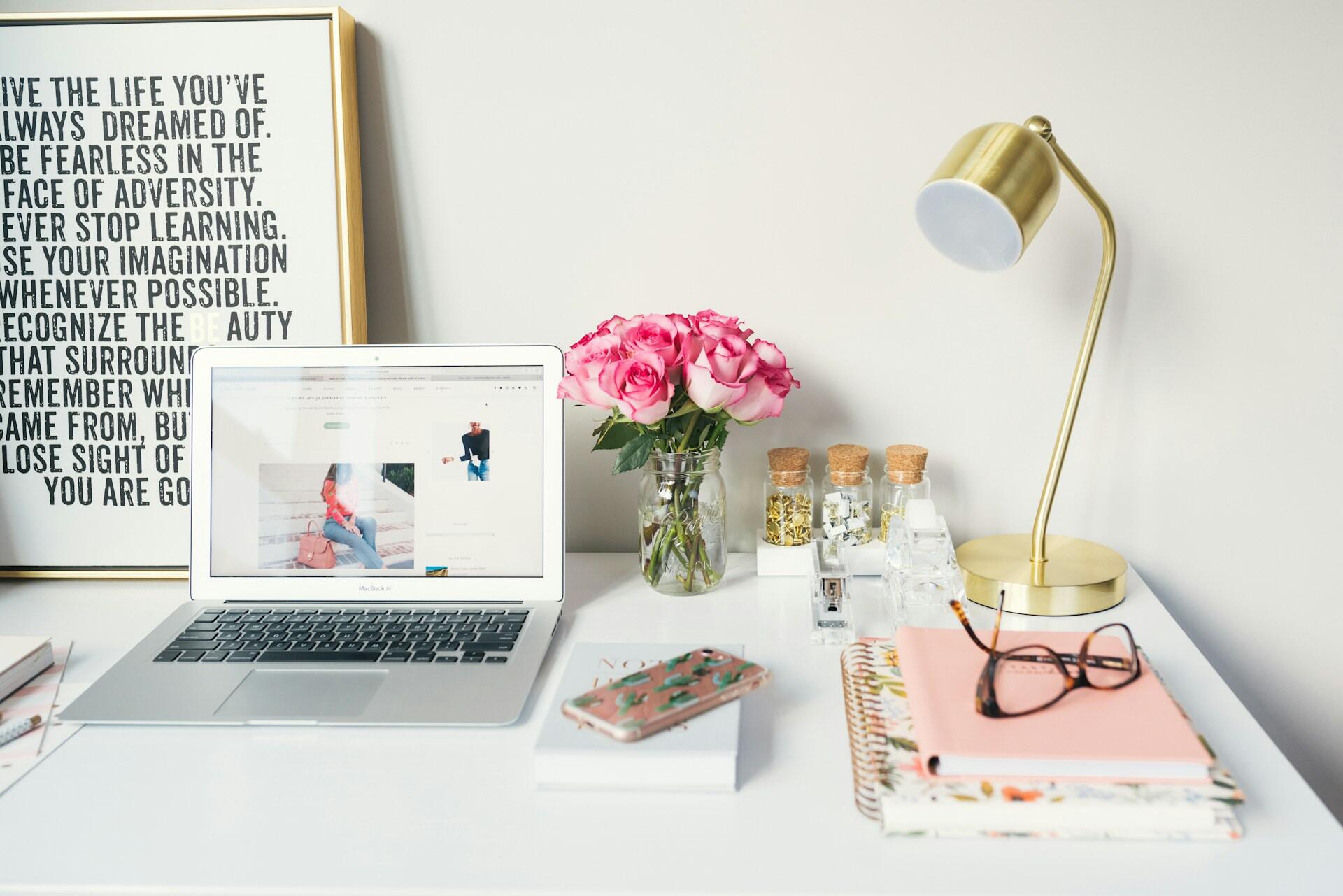 A study desk with a book, a laptop, and stationery.
