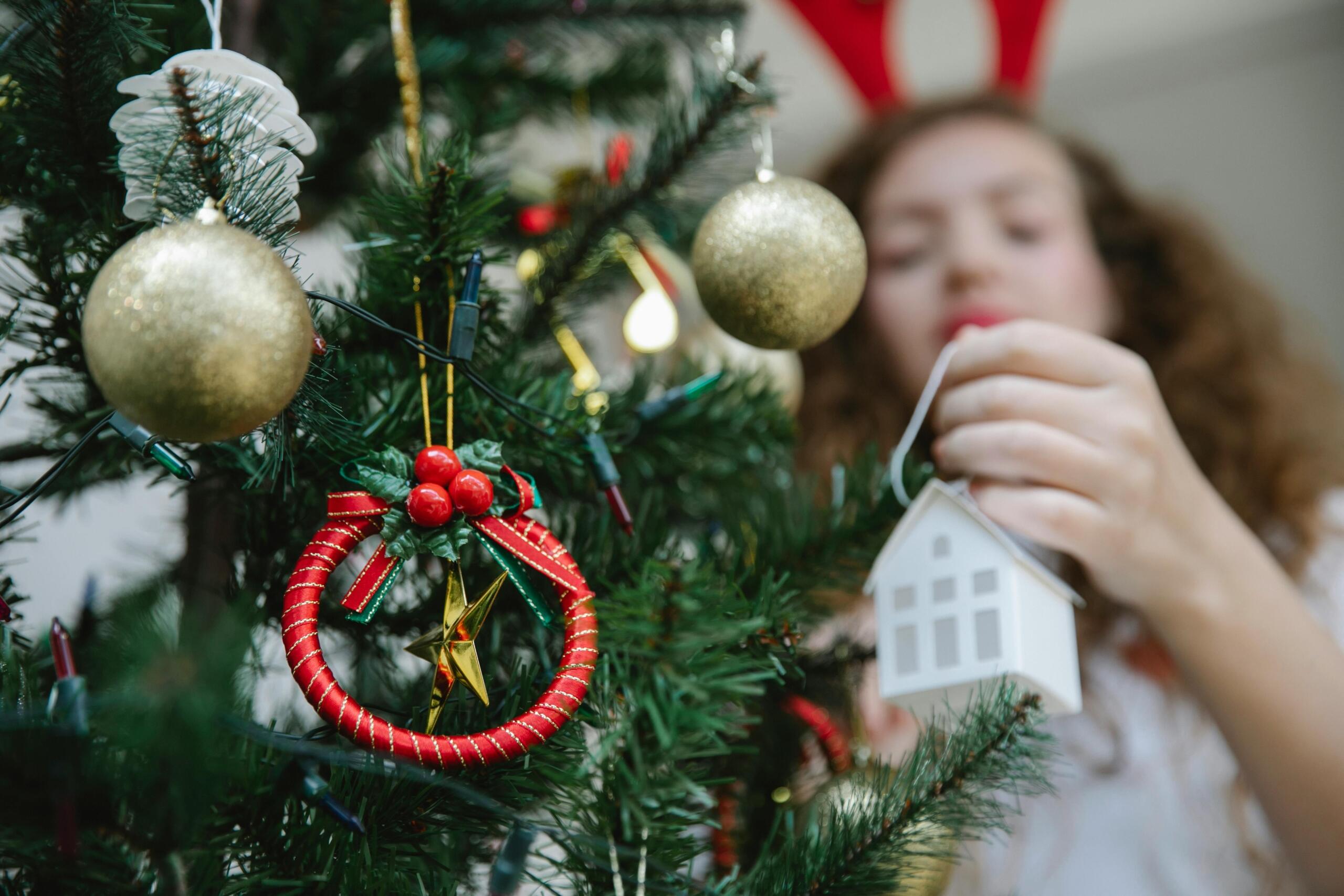 A woman decorating a Christmas tree.