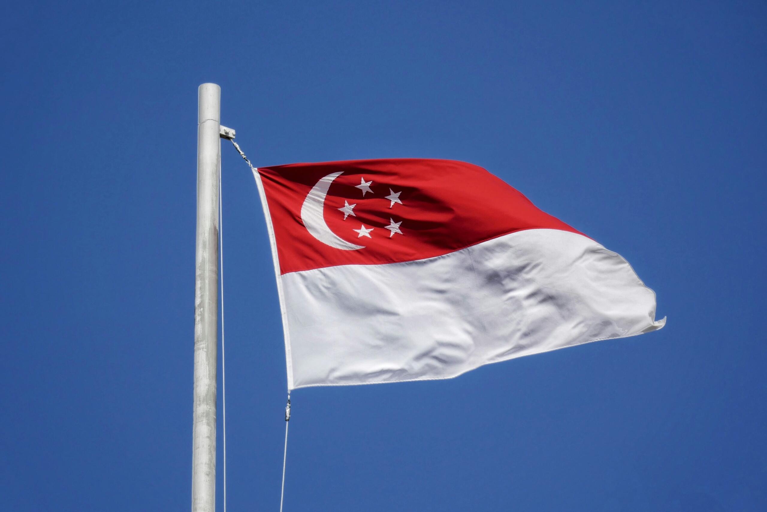 The flag of Singapore against a blue sky.
