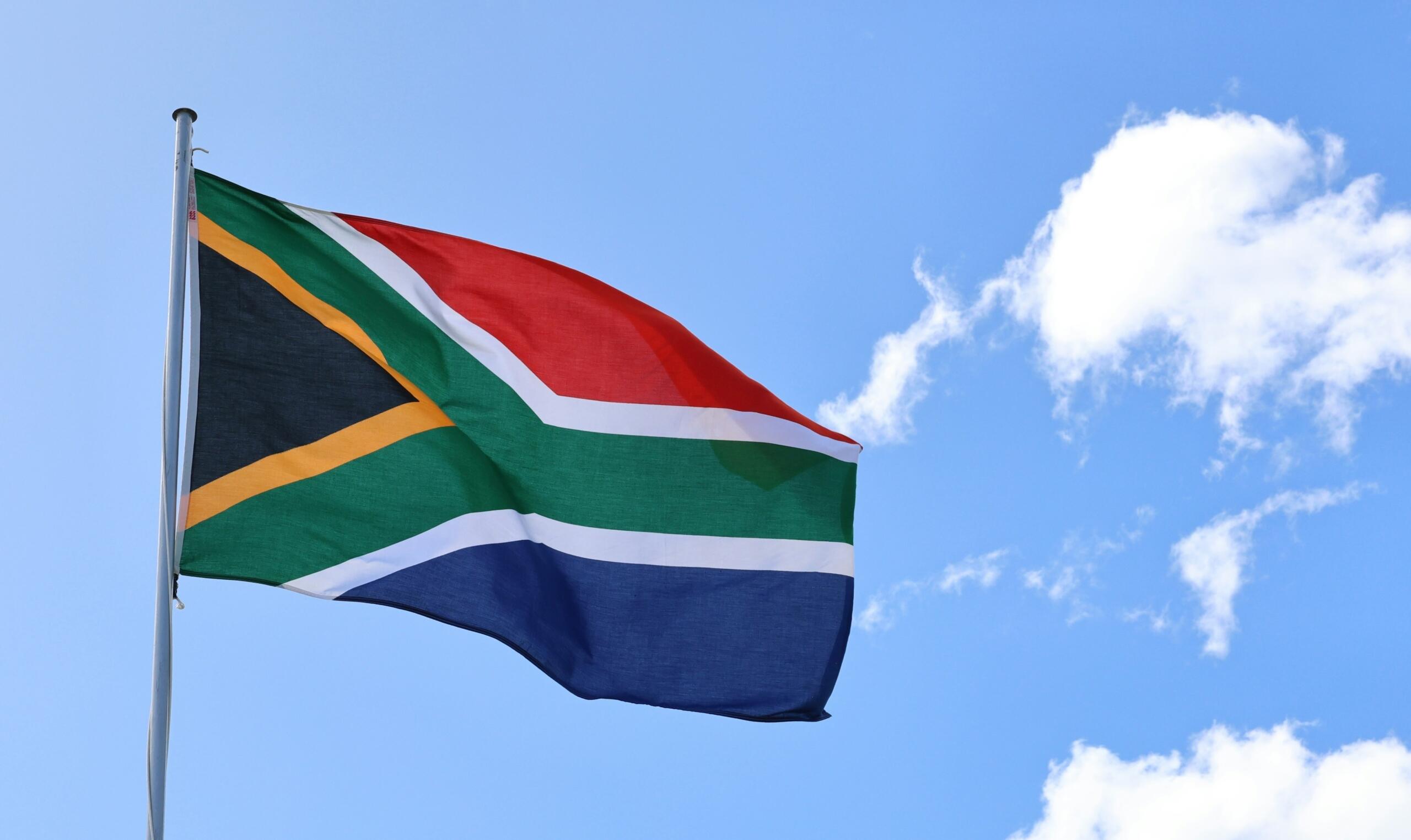 The South Africa flag against a blue sky.
