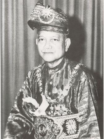 An image of a Malaysian royal (the first Agong, TUanku Abdul Rahman Ibni Al-Marhum) in traditional attire with ornate headdress and medals.