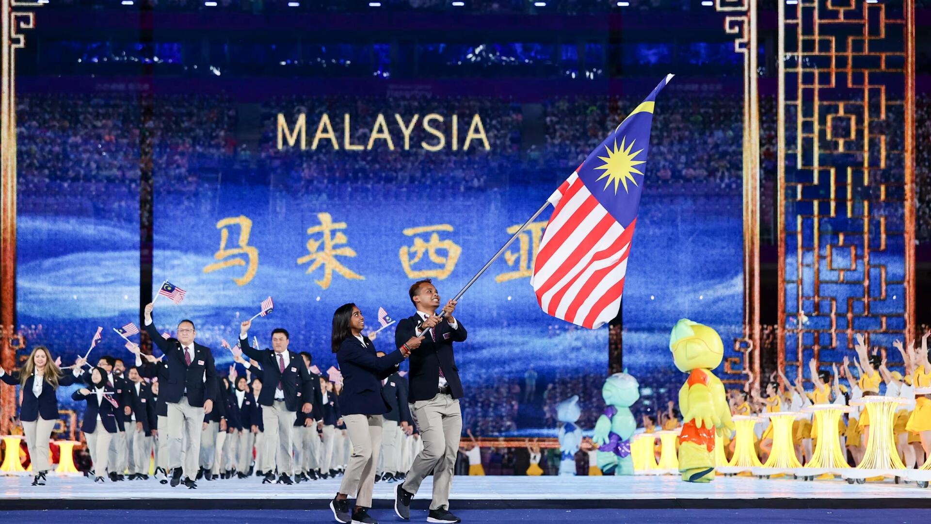 Malaysian athletes proudly wave the national flag during the 2018 Asian Games opening ceremony in Beijing.