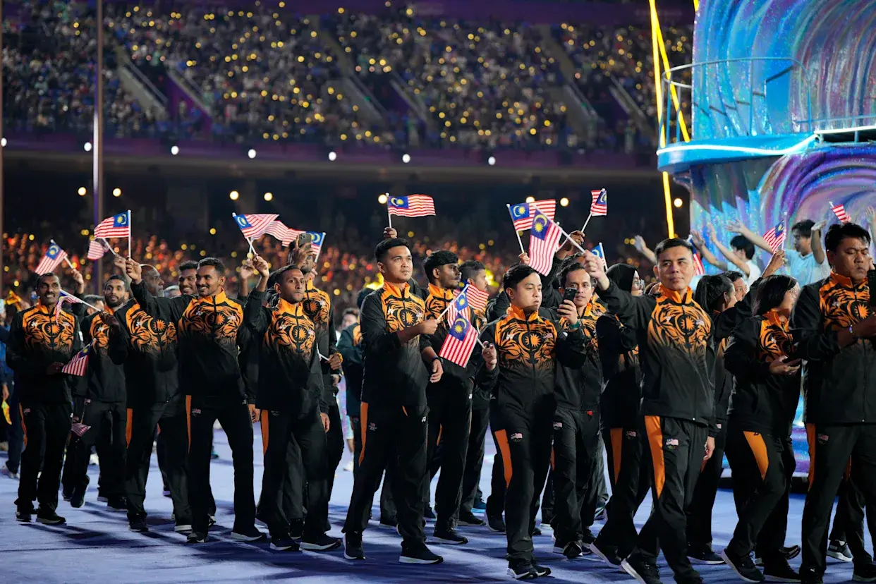 Athletes carrying flags walk down the steps, celebrating their countries in a festive and spirited procession.