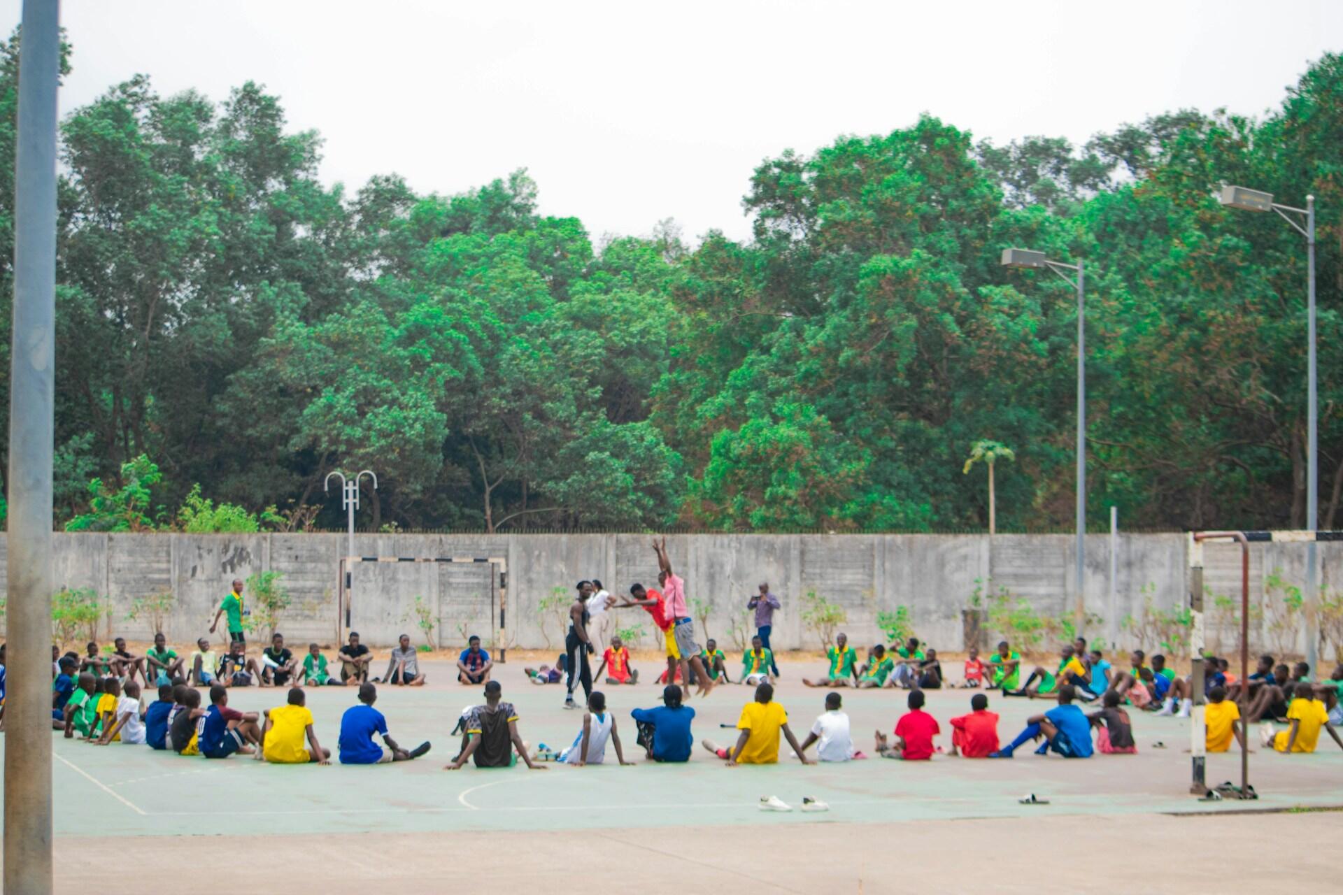 A group of athletes gather around a coach at a training site