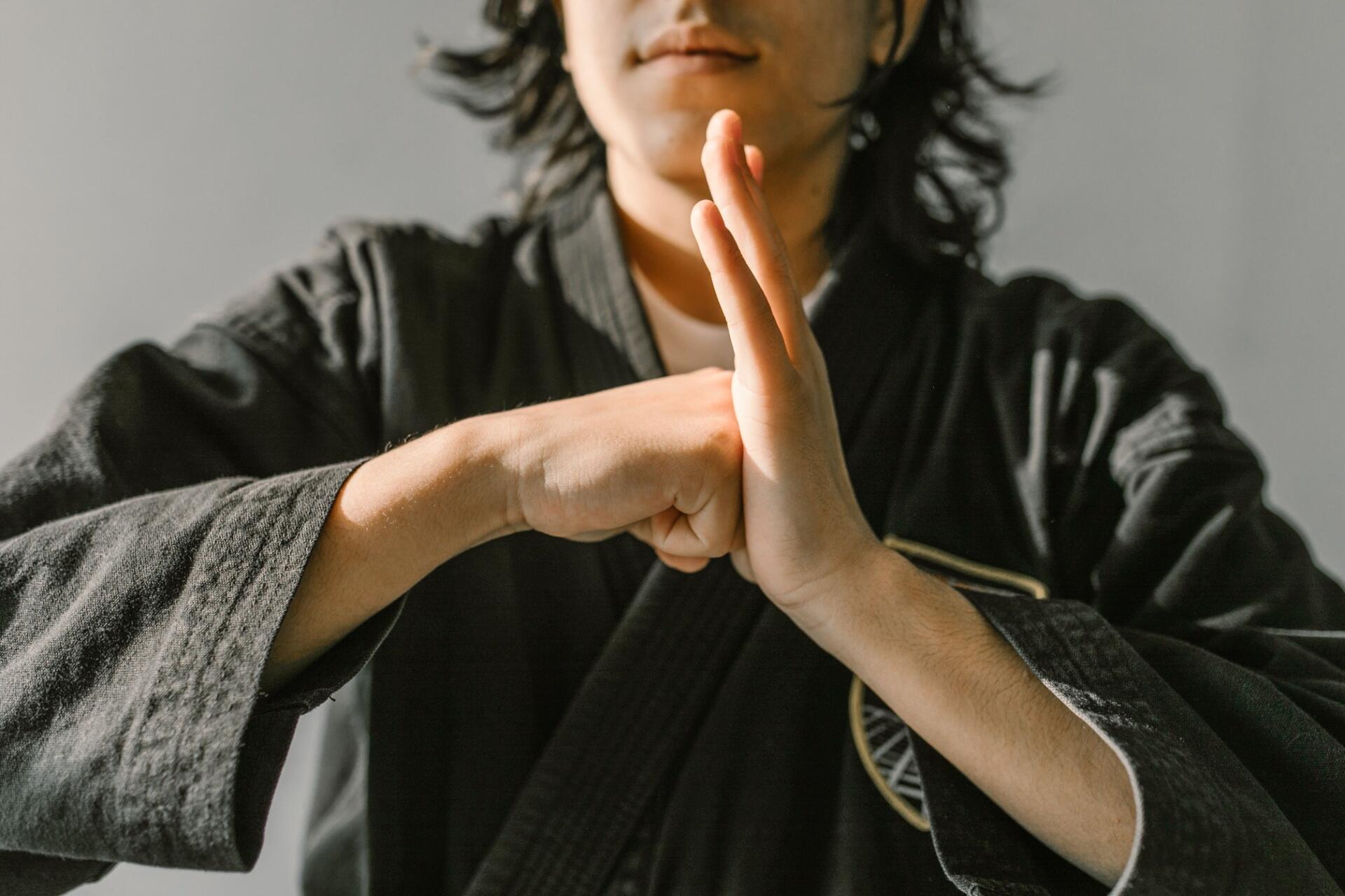 Martial artist practising a combat technique in a training environment, demonstrating strength, focus, discipline, and precise movement.