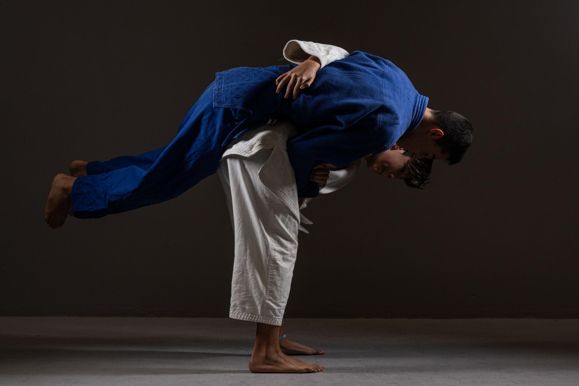Judo athletes performing a dynamic throw on a tatami mat demonstrating balance, leverage, and technique
