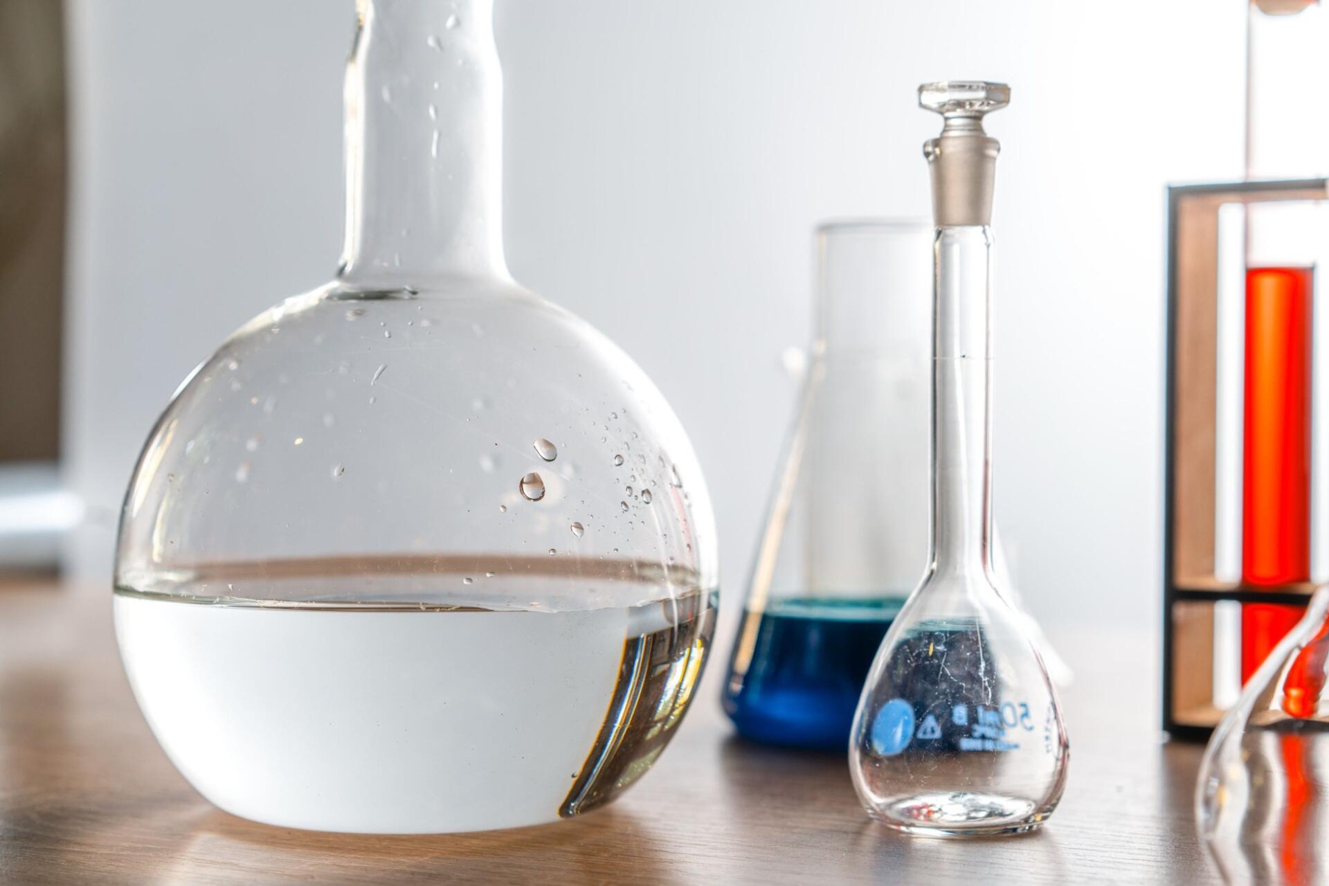 Volumetric flasks and laboratory glassware used for preparing and measuring chemical solutions.
