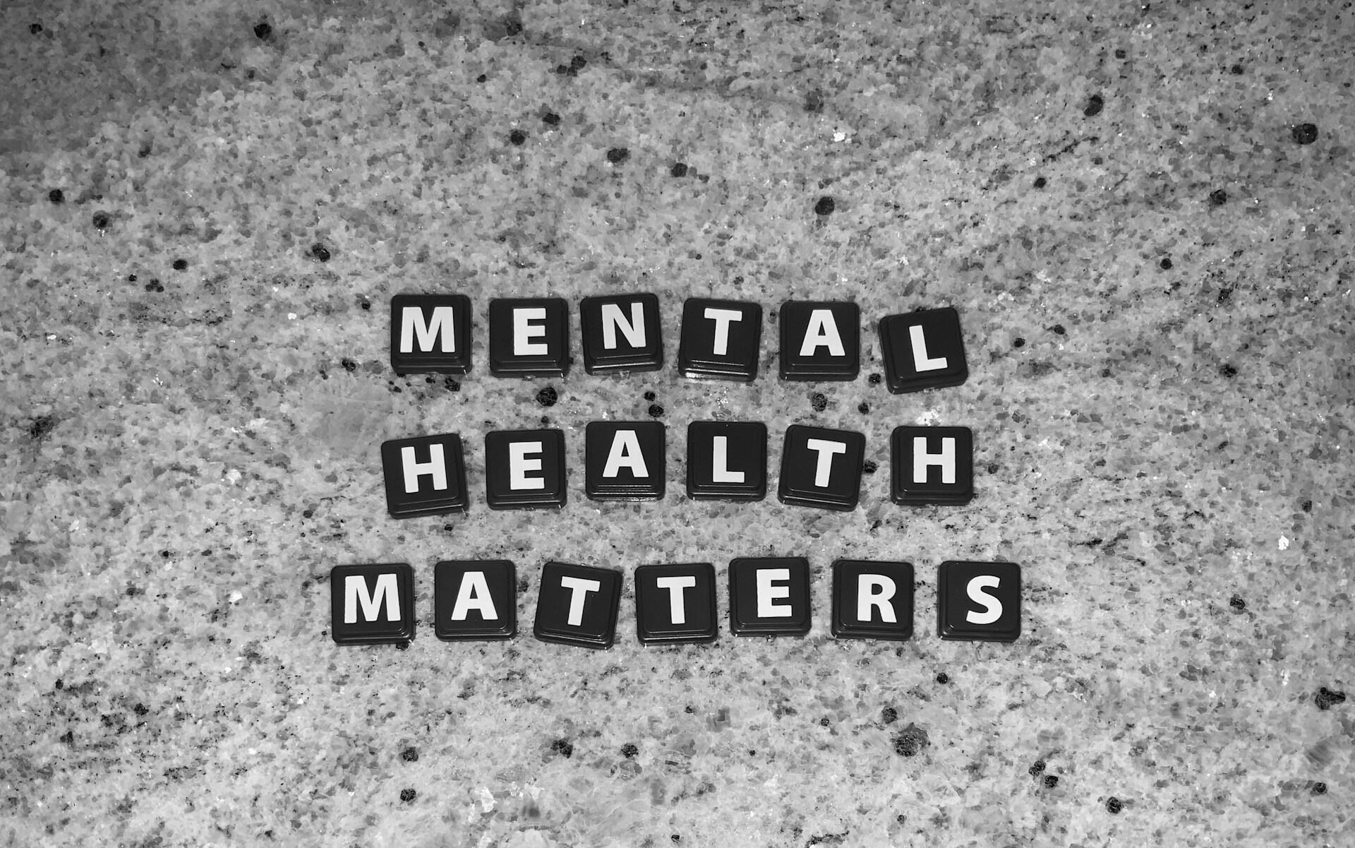 Mental health matters displayed with black letter tiles on a textured surface.