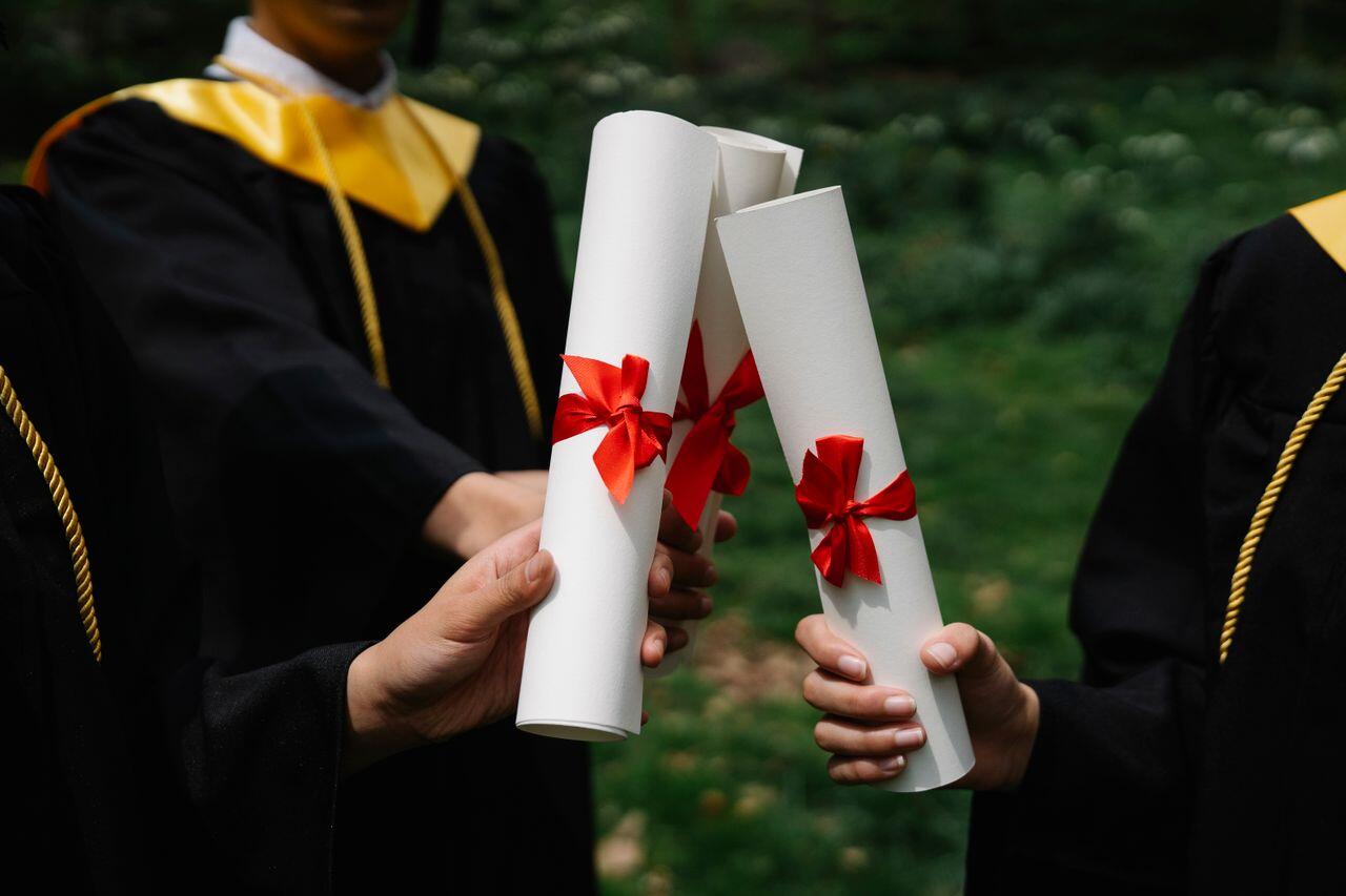 a picture of 2 people holding their degrees