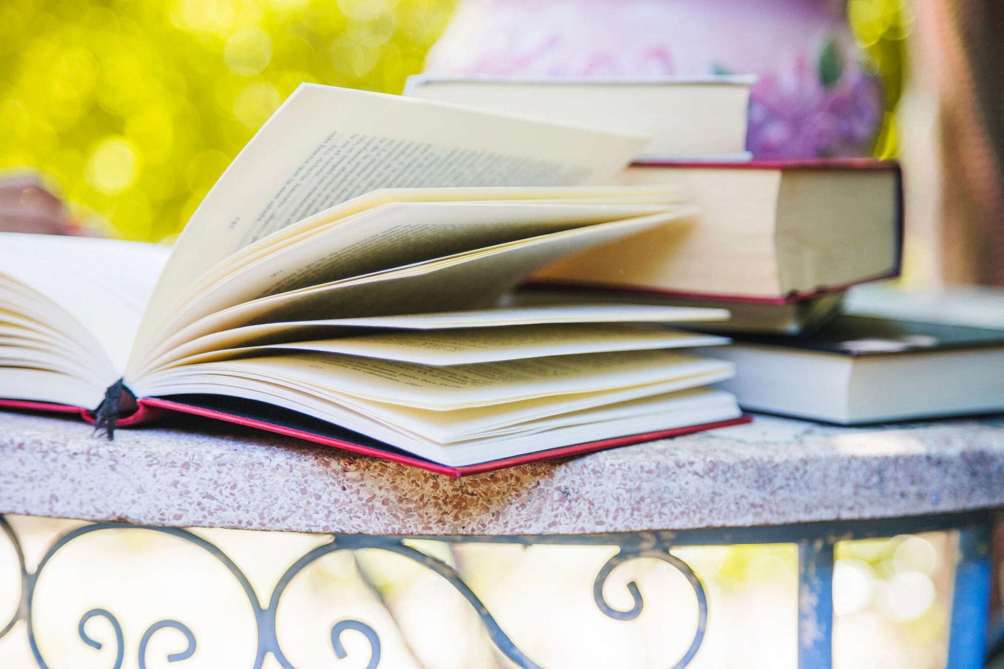 A collection of books stacked on a table, showcasing different colors and sizes.