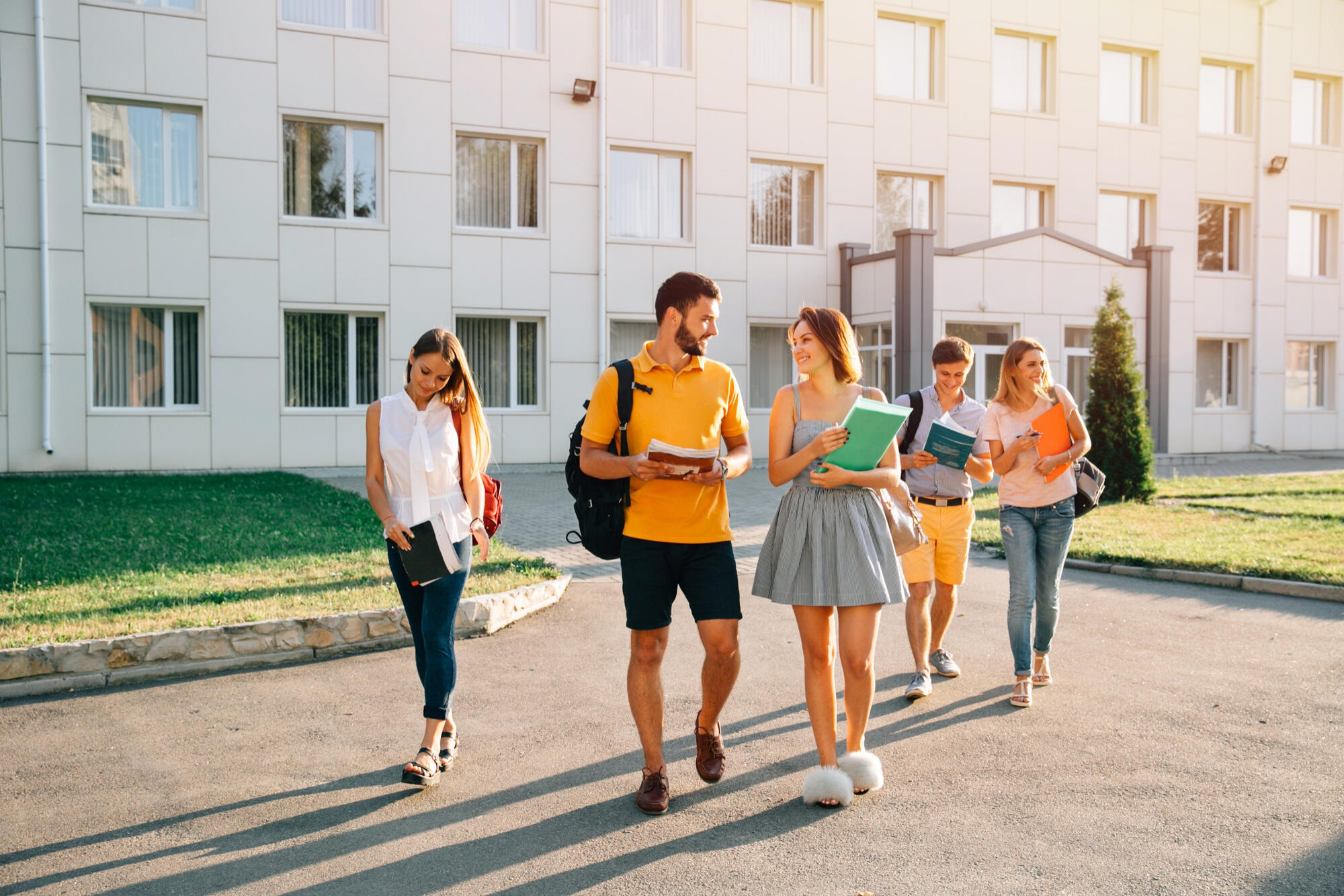 A diverse group of students walking together on a city street, engaged in conversation and enjoying their time outdoors.