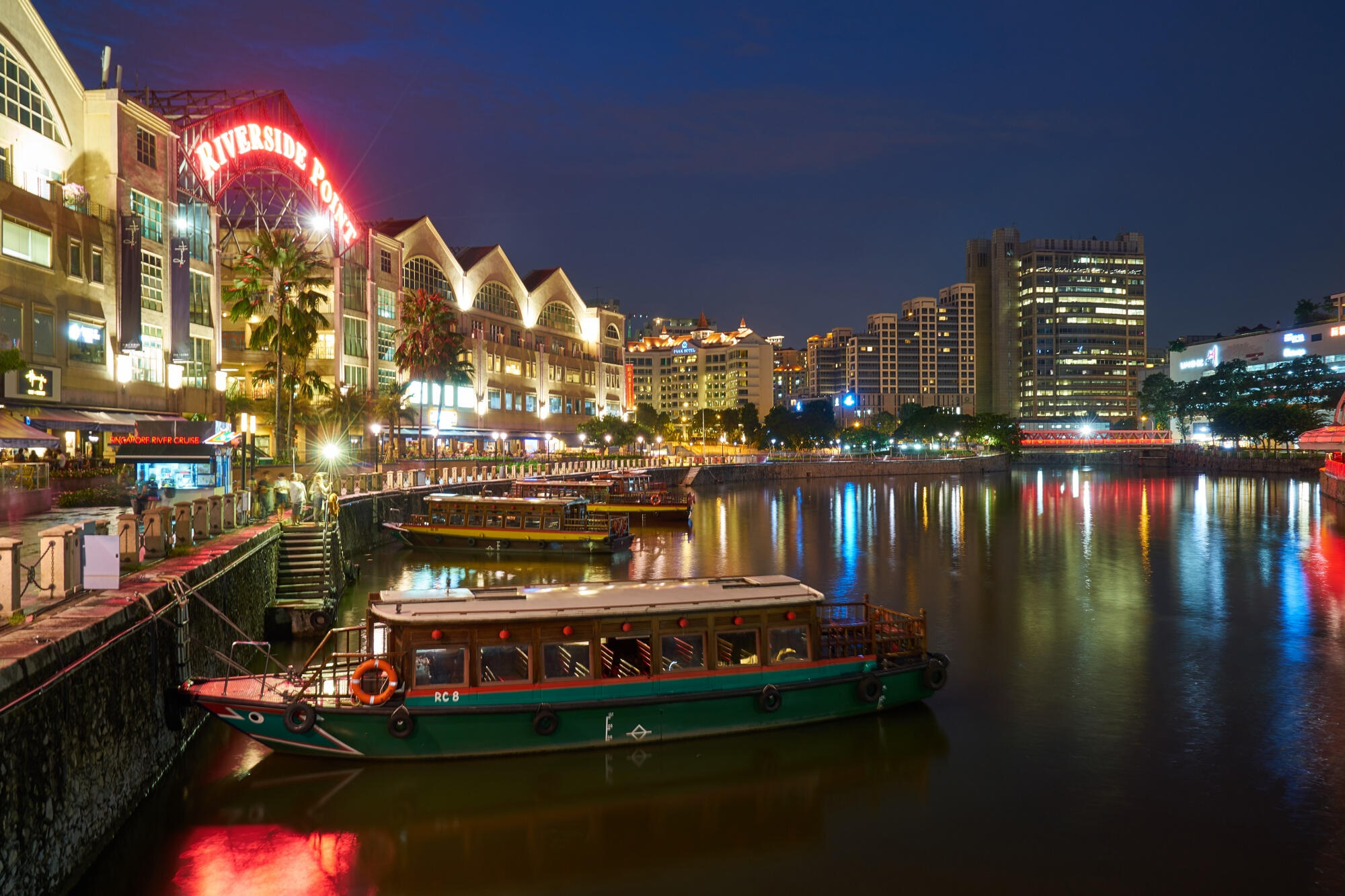 A serene body of water reflecting the sky, surrounded by lush greenery and distant hills.