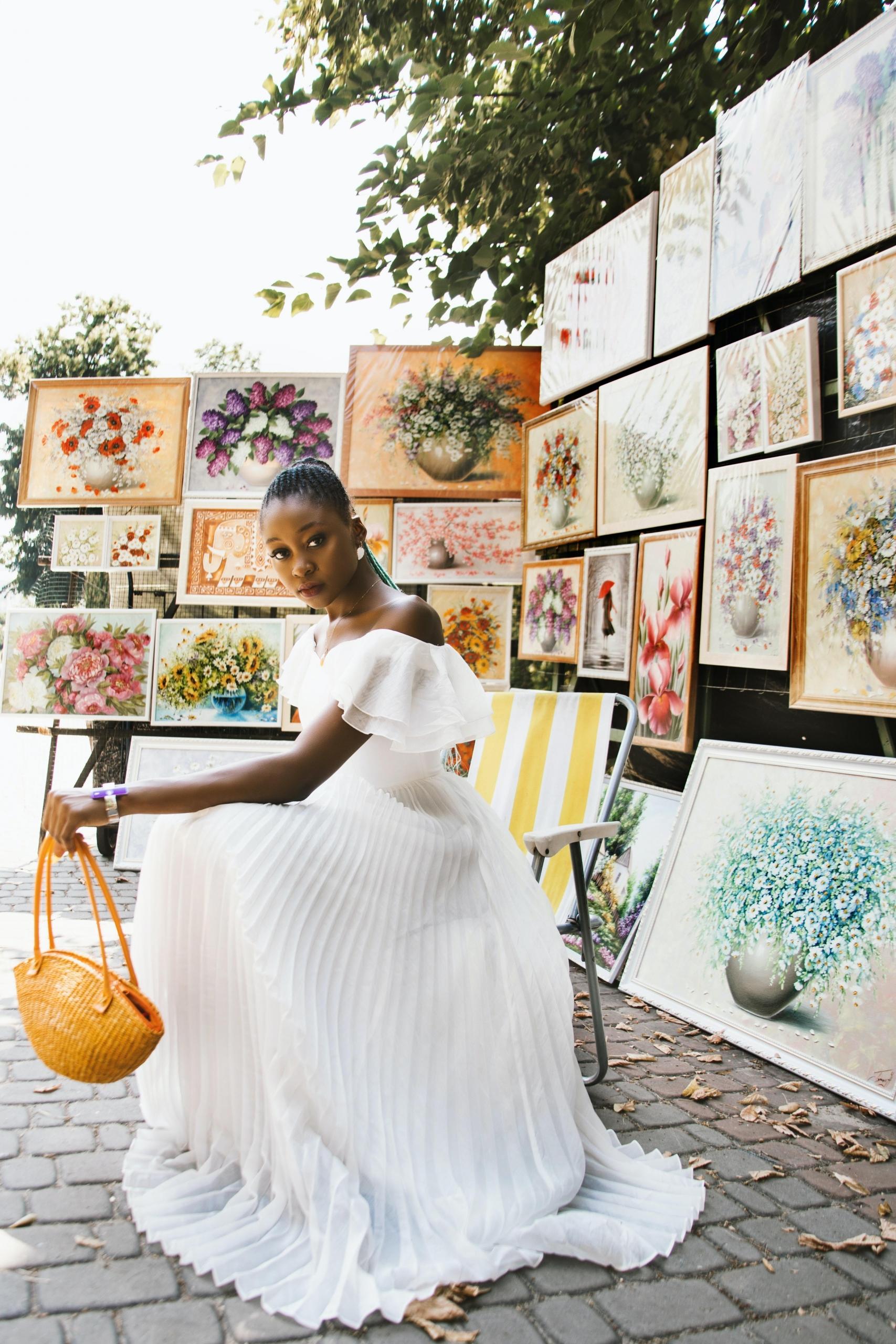 A female artist surrounded by paintings.
