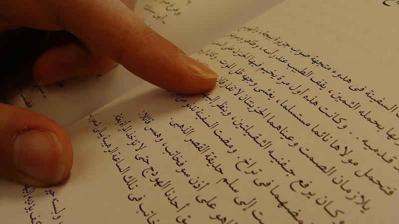Finger tracing an Arabic text
