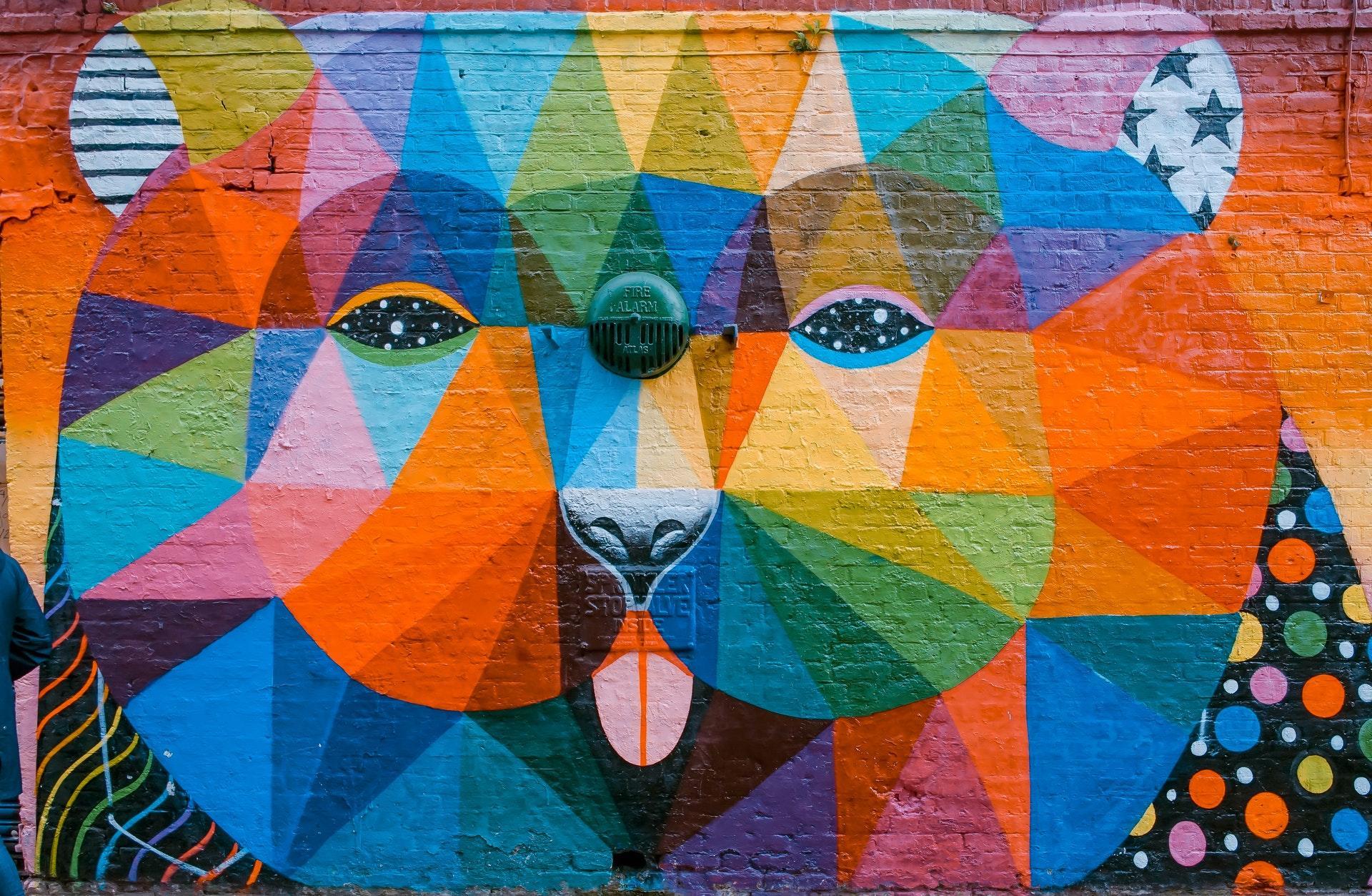 Multiple paintings of the face on a wall