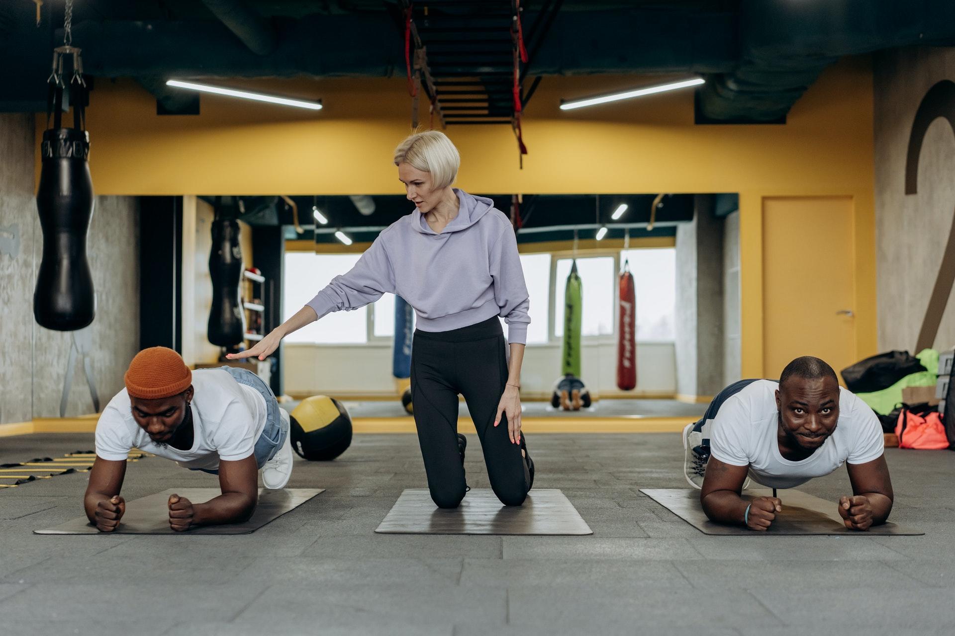 Two men exercising with a personal trainer