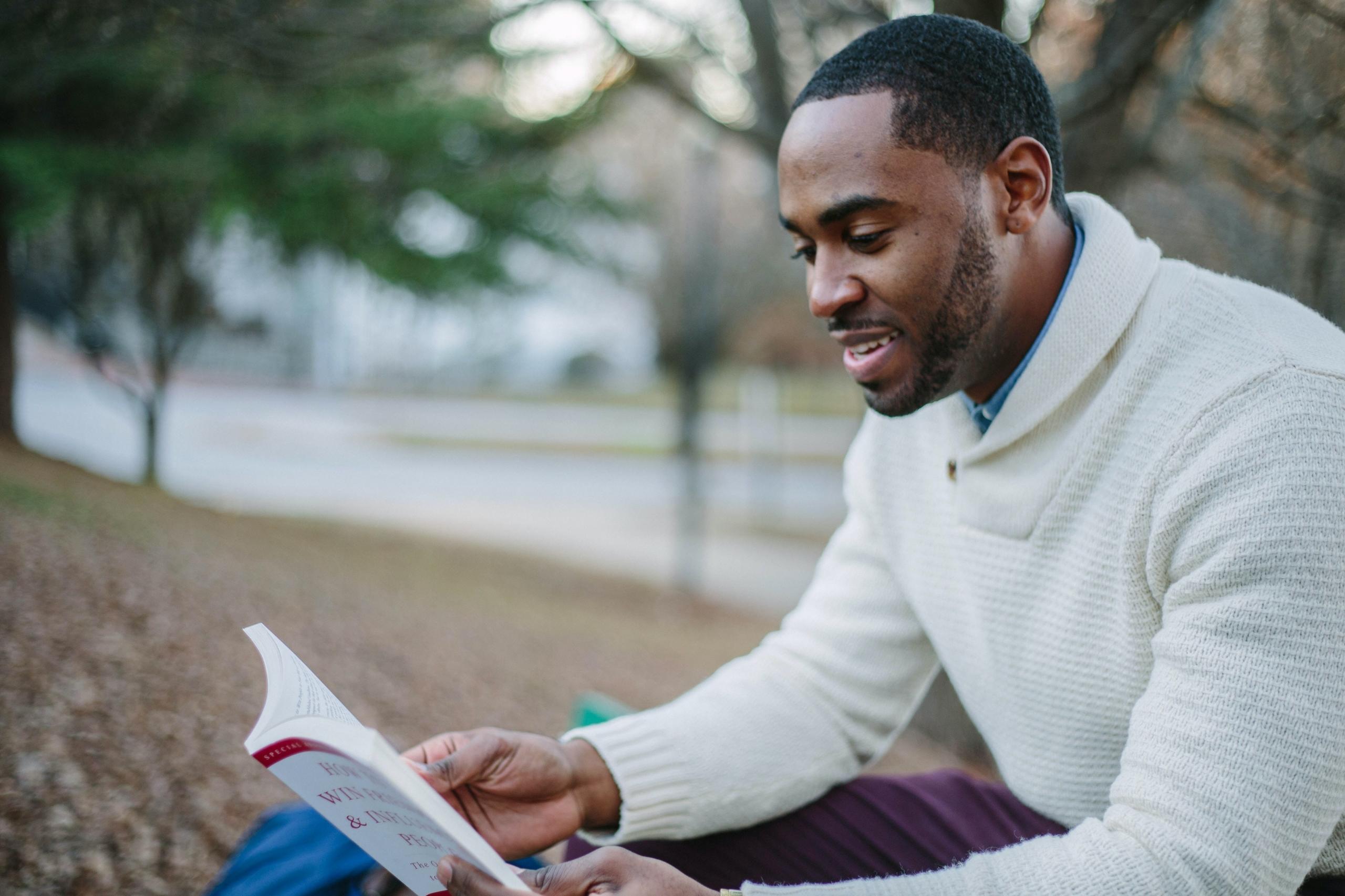 A young man reading outdoors